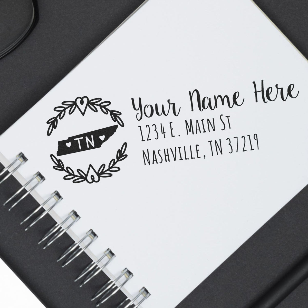 Personalized return address rubber stamp imprint with Tennessee state design on notebook page.