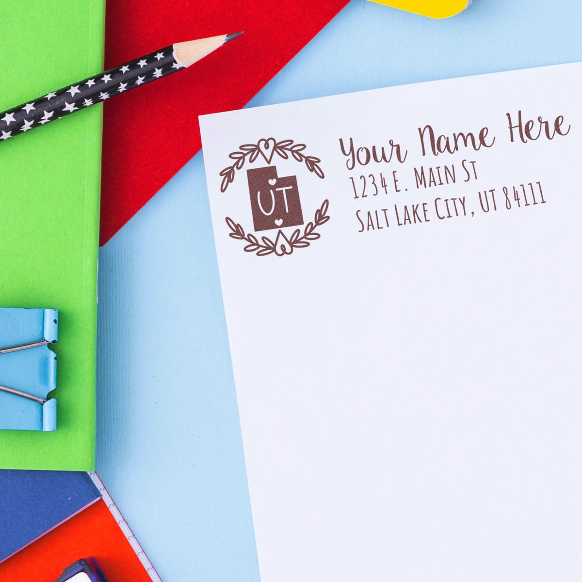 Custom Utah return address rubber stamp on a white envelope with colorful stationery, ideal for personalized mailing.
