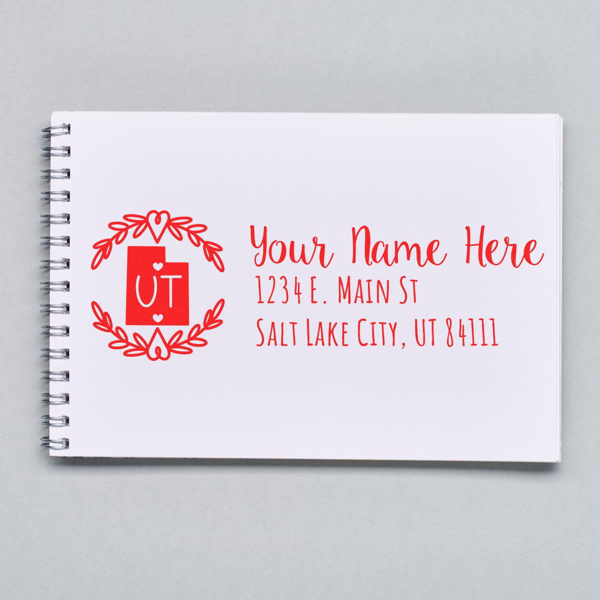 Custom Utah return address rubber stamp design on notebook, featuring name, street address, and Salt Lake City, UT 84111.