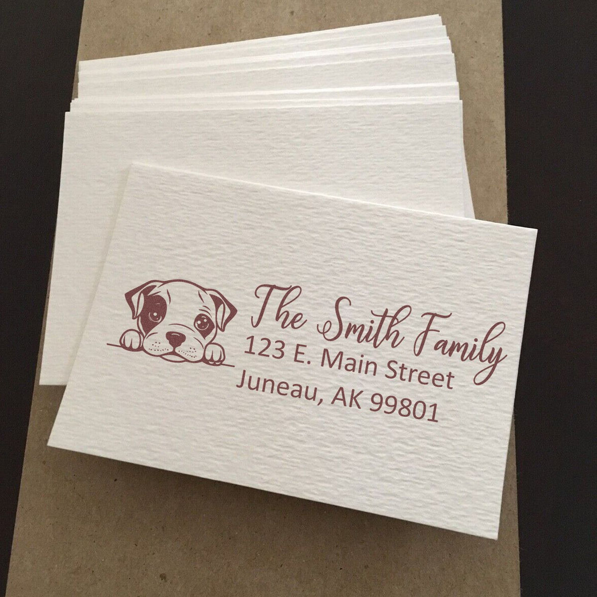 Custom rubber stamp on textured napkins with dog logo and personalized family return address for wedding or event use.
