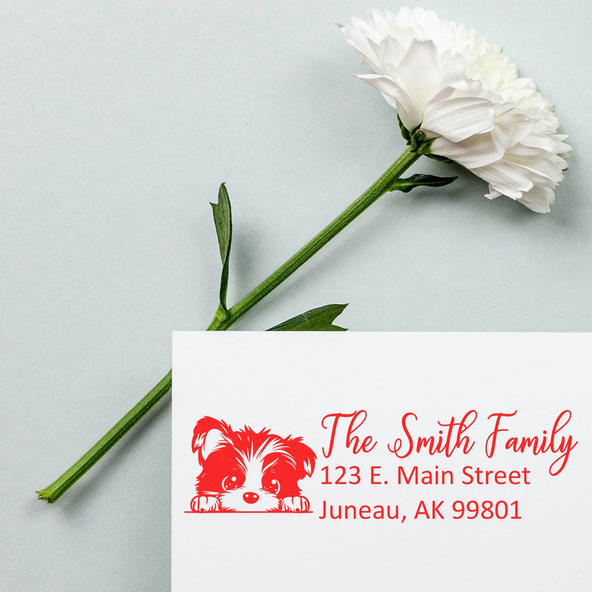 Personalized return address rubber stamp with dog design for The Smith Family, Juneau, AK, on a white envelope.