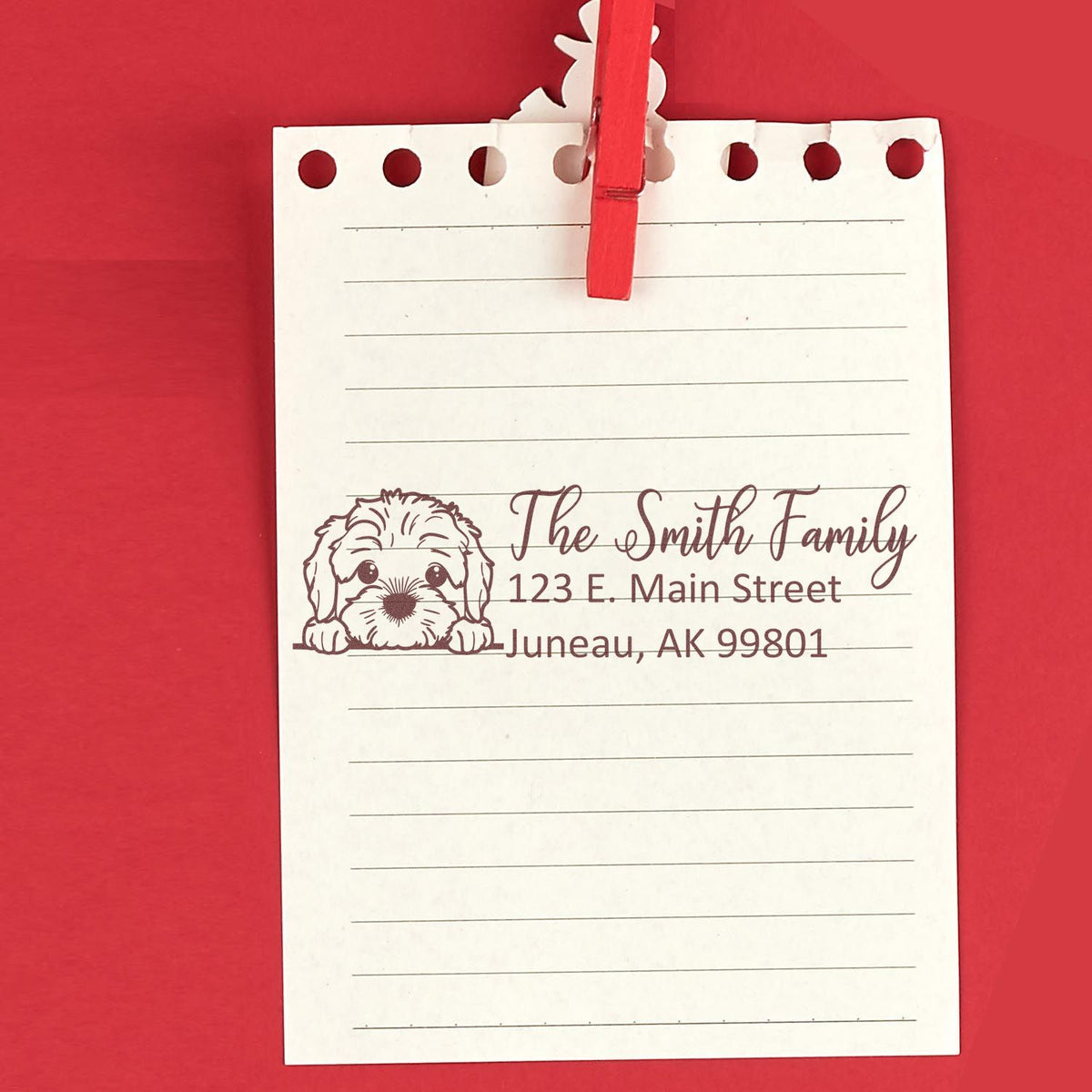 Personalized dog address rubber stamp for custom stationery, showing family name and mailing address on lined notepaper.