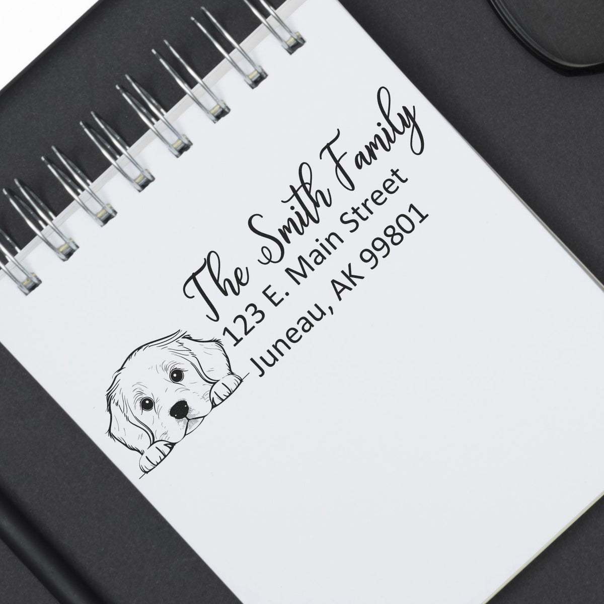 Custom family address rubber stamp with dog illustration, featuring The Smith Family and Juneau, AK address on notebook paper.