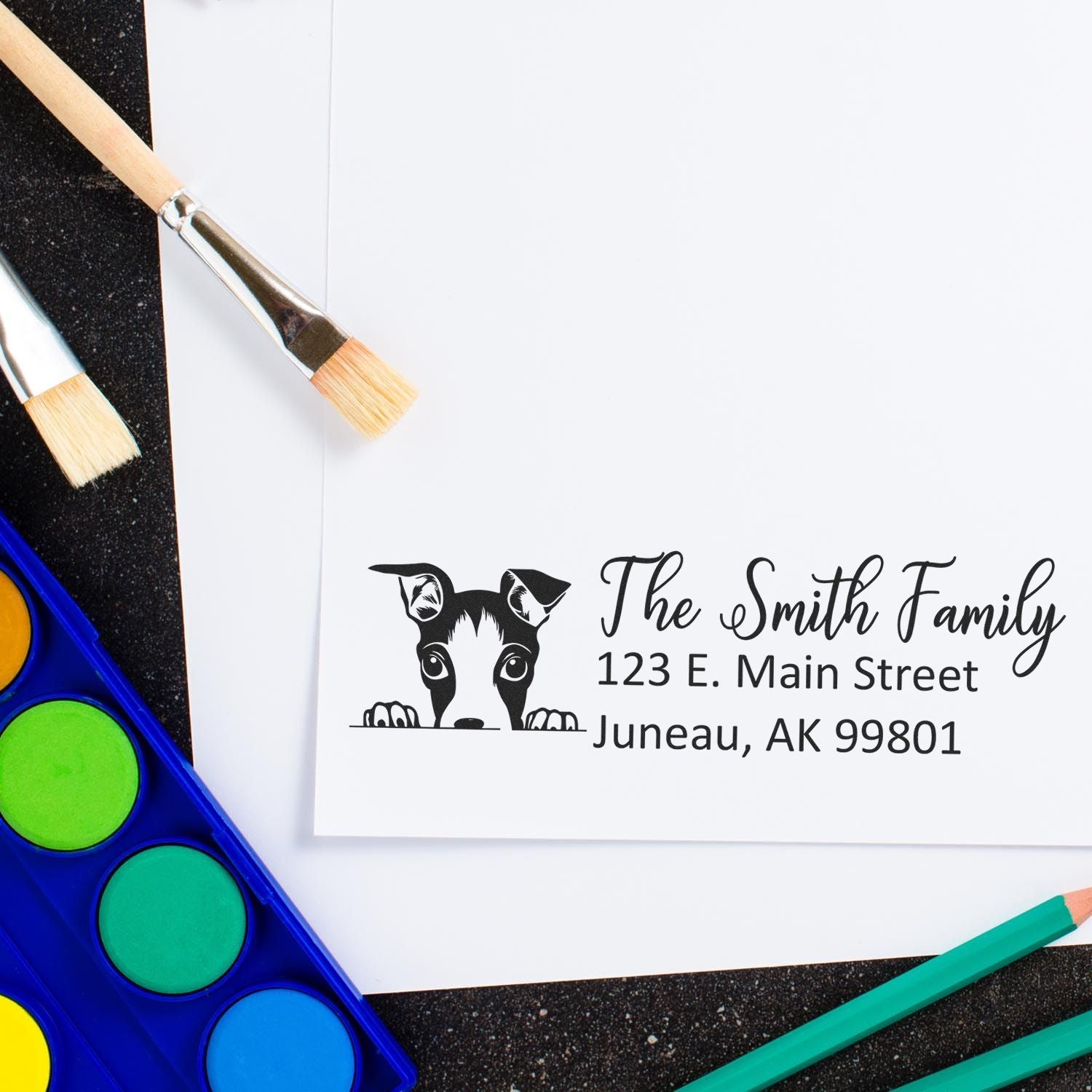 Custom dog return address rubber stamp with The Smith Family, Juneau AK address, shown with watercolor supplies.