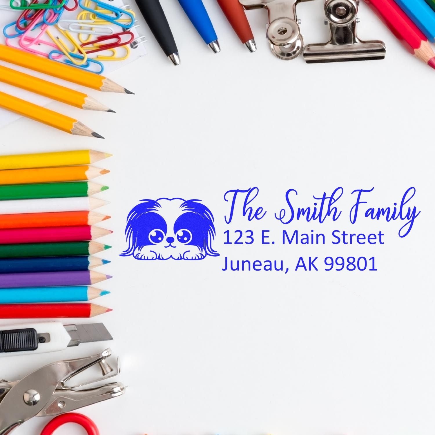 Custom rubber address stamp with dog logo and The Smith Family return address, framed by colorful school and office supplies.