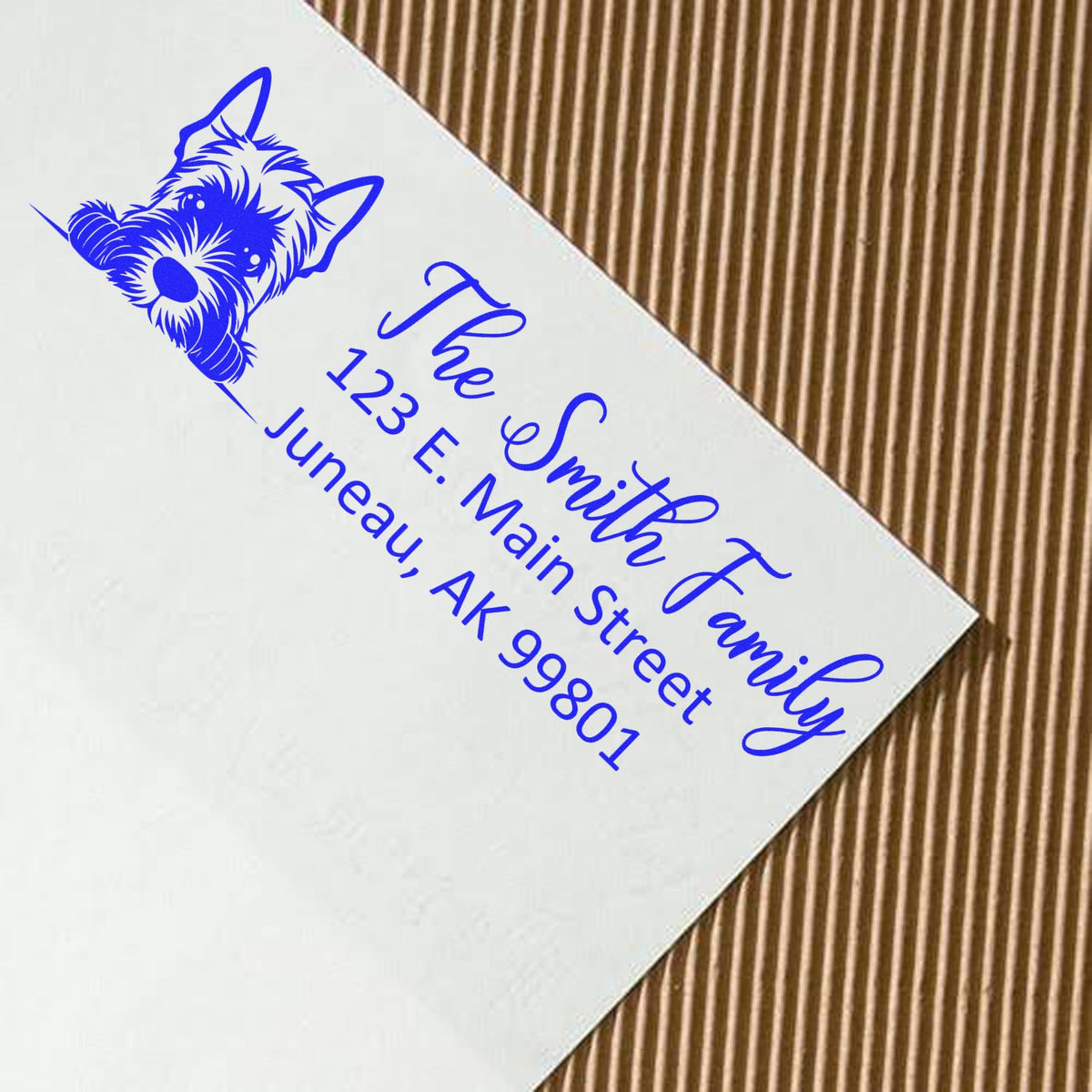 Blue custom address rubber stamp with dog logo, family name, and mailing address on an envelope.