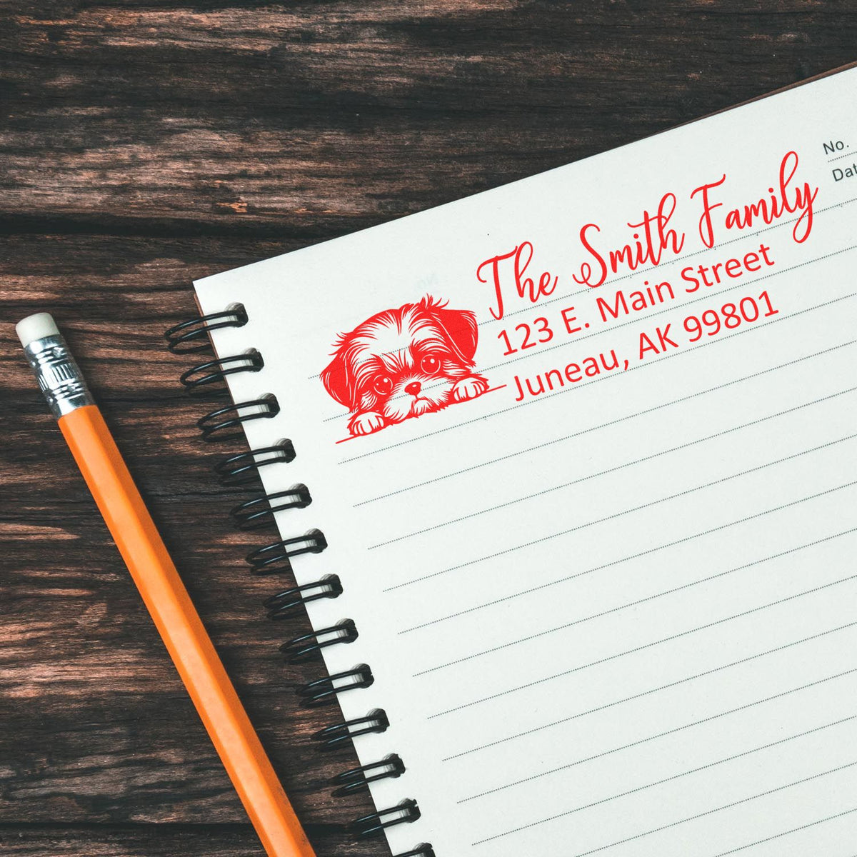 Personalized family address rubber stamp with dog motif on notebook, perfect for custom mailing and stationery.