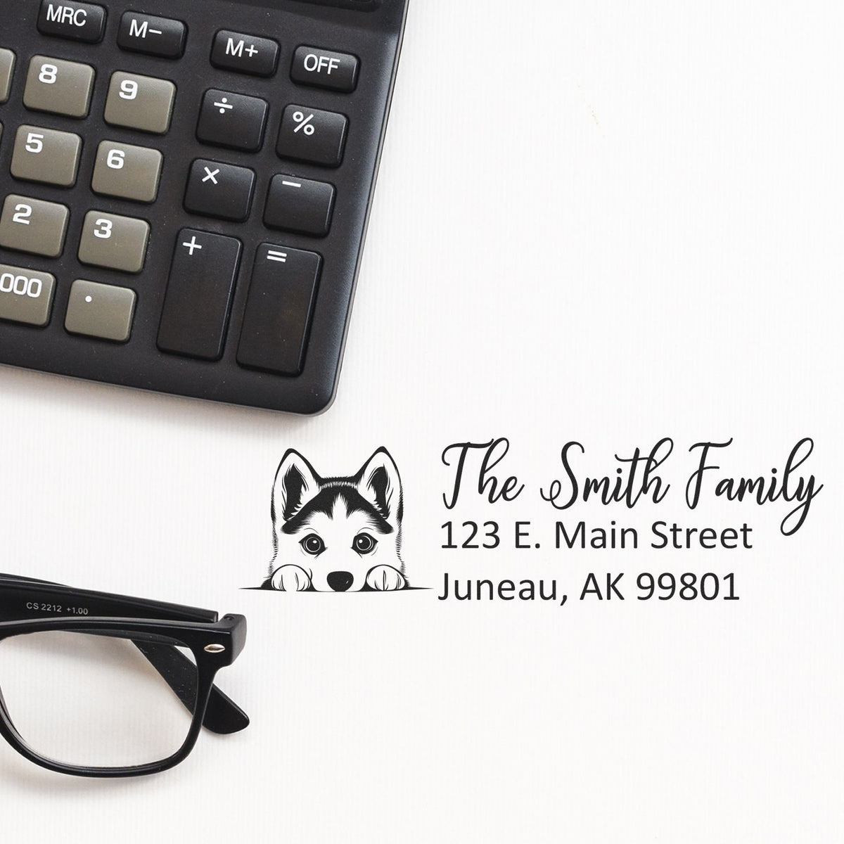 Custom rubber stamp design with husky dog, Smith family name and address, shown with calculator and glasses for home business use.