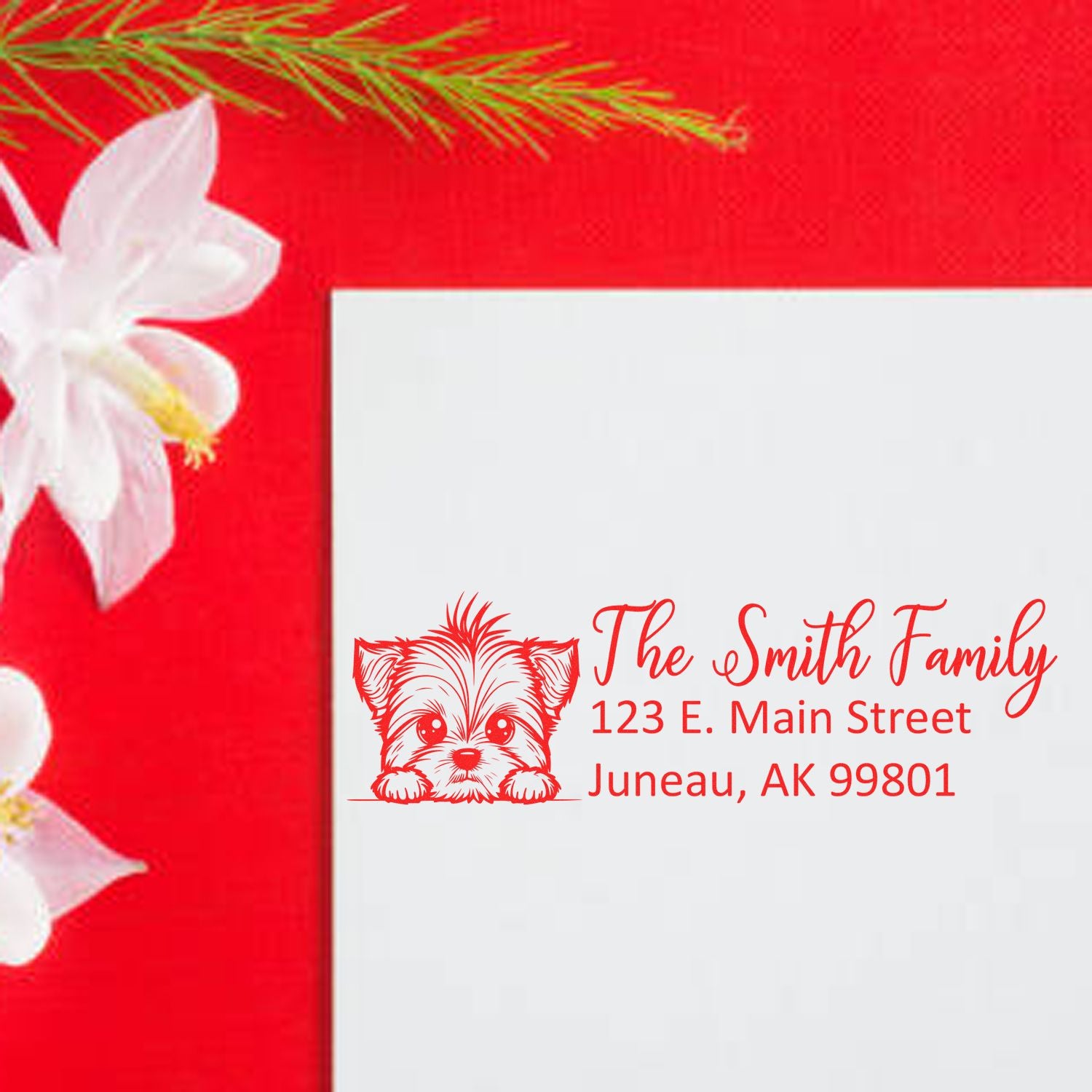 Custom family return address rubber stamp with dog illustration on a red holiday card background.