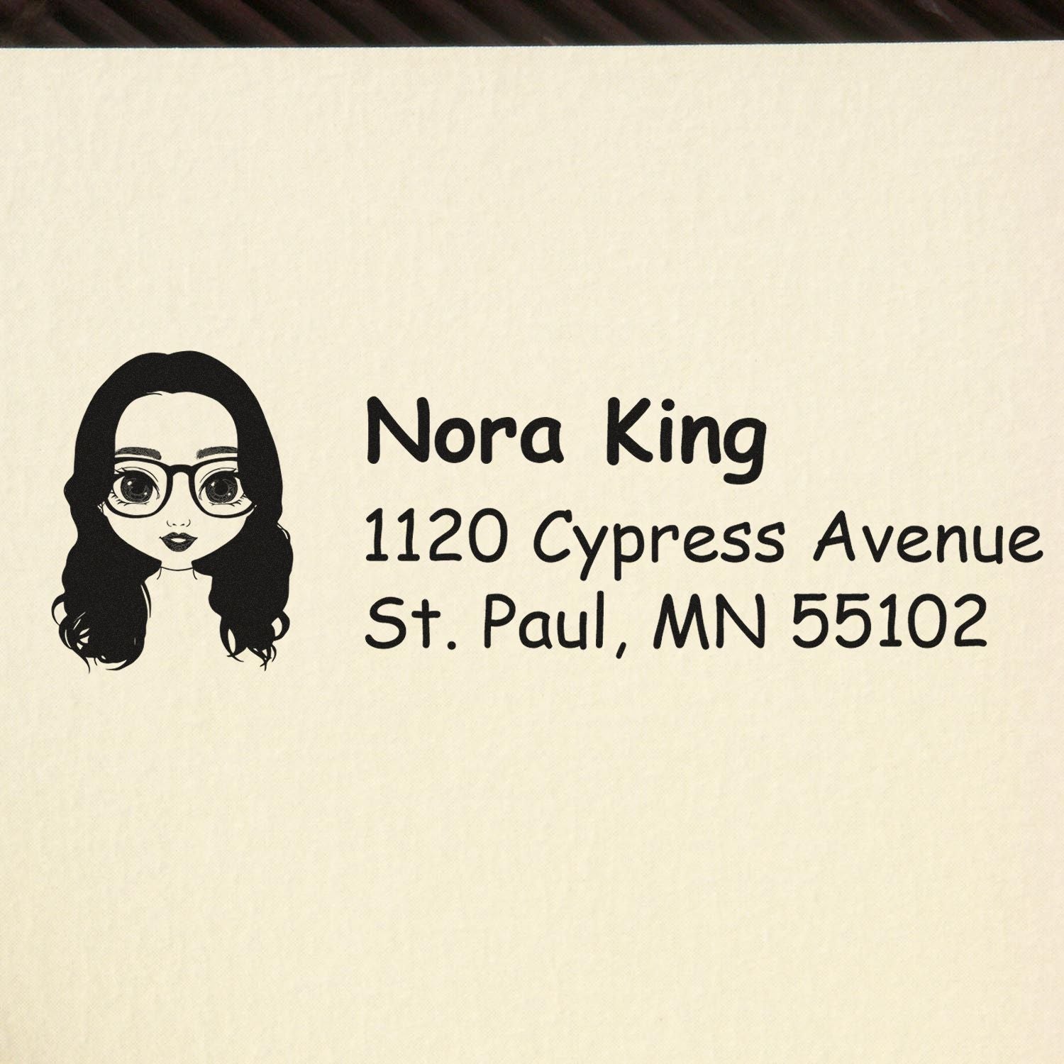 Personalized return address rubber stamp with woman avatar, Nora King, 1120 Cypress Avenue, St. Paul, MN 55102.