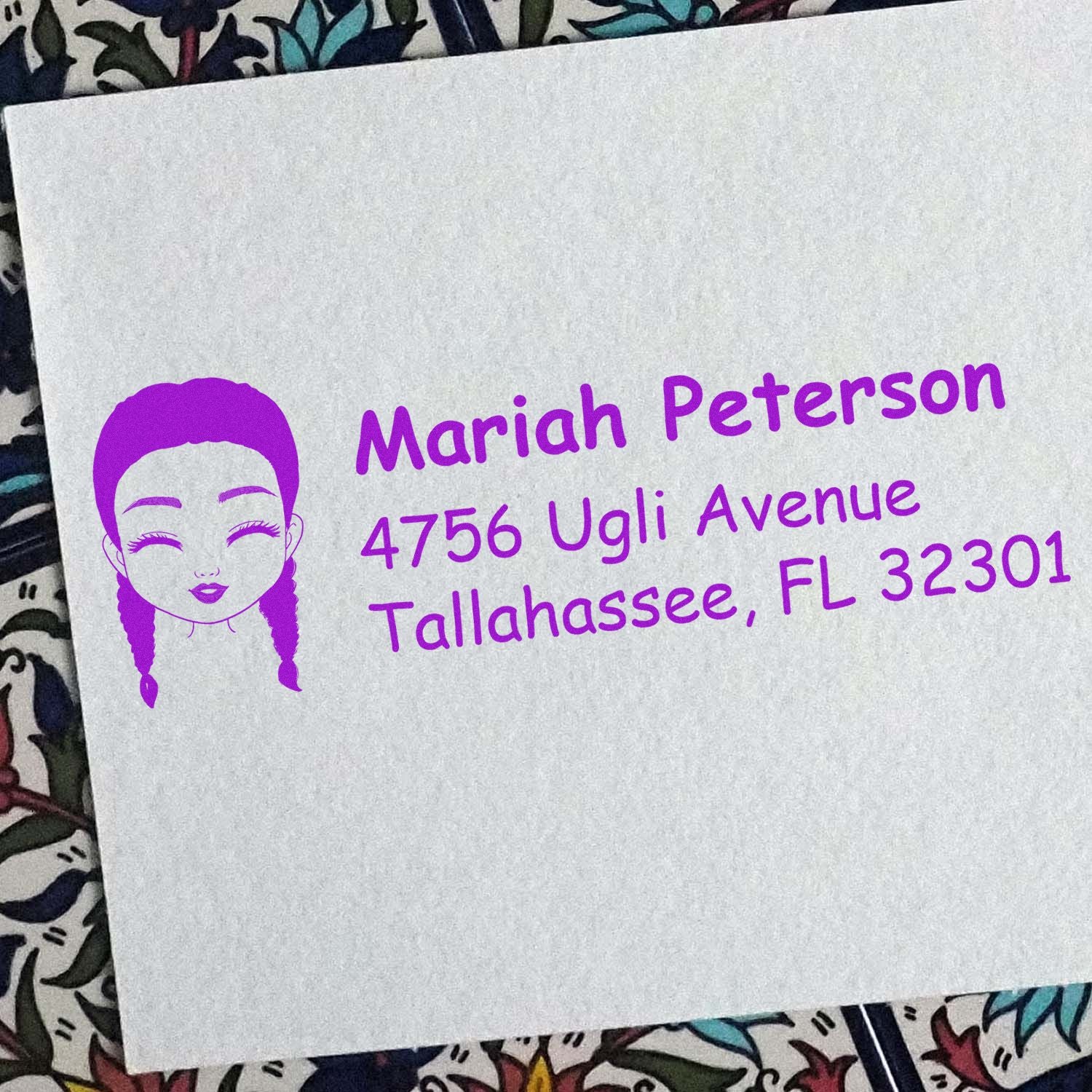 Personalized rubber address stamp with girl logo, showing Mariah Peterson return address in purple ink.