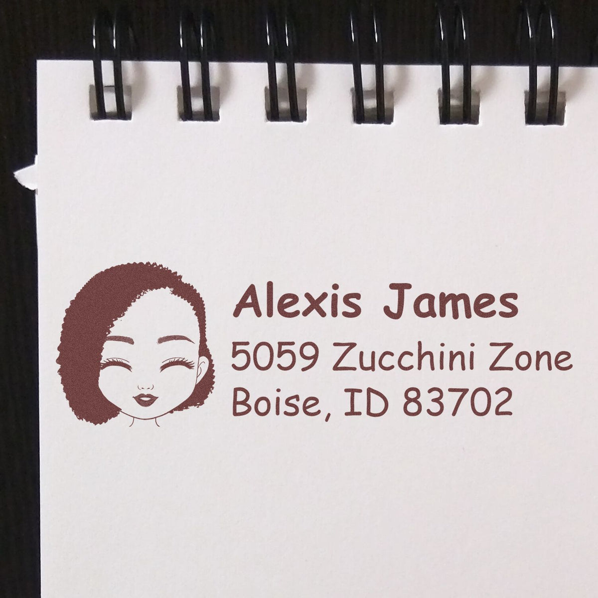Custom return address rubber stamp with logo for Alexis James, 5059 Zucchini Zone, Boise, ID 83702.