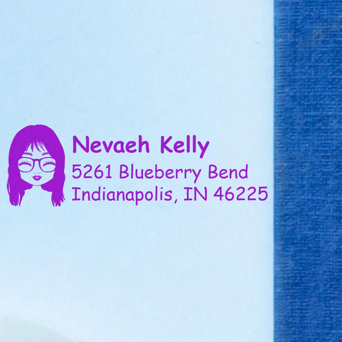 Personalized return address rubber stamp with avatar logo, Nevaeh Kelly, and Indianapolis, IN 46225 in purple ink.