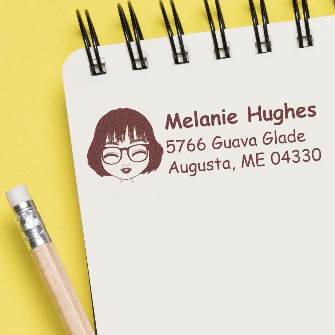 Custom return address rubber stamp with name and mailing address printed on a notepad, ideal for envelopes and mailings.