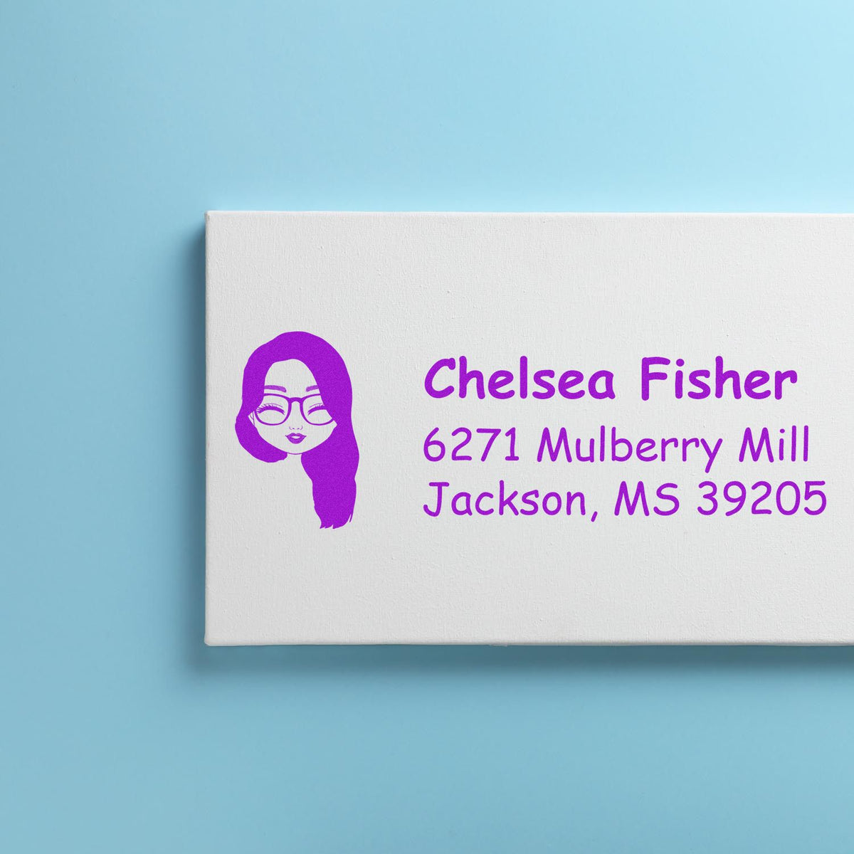 Personalized return address rubber stamp with purple avatar logo, name, and mailing address on a white stamp block.