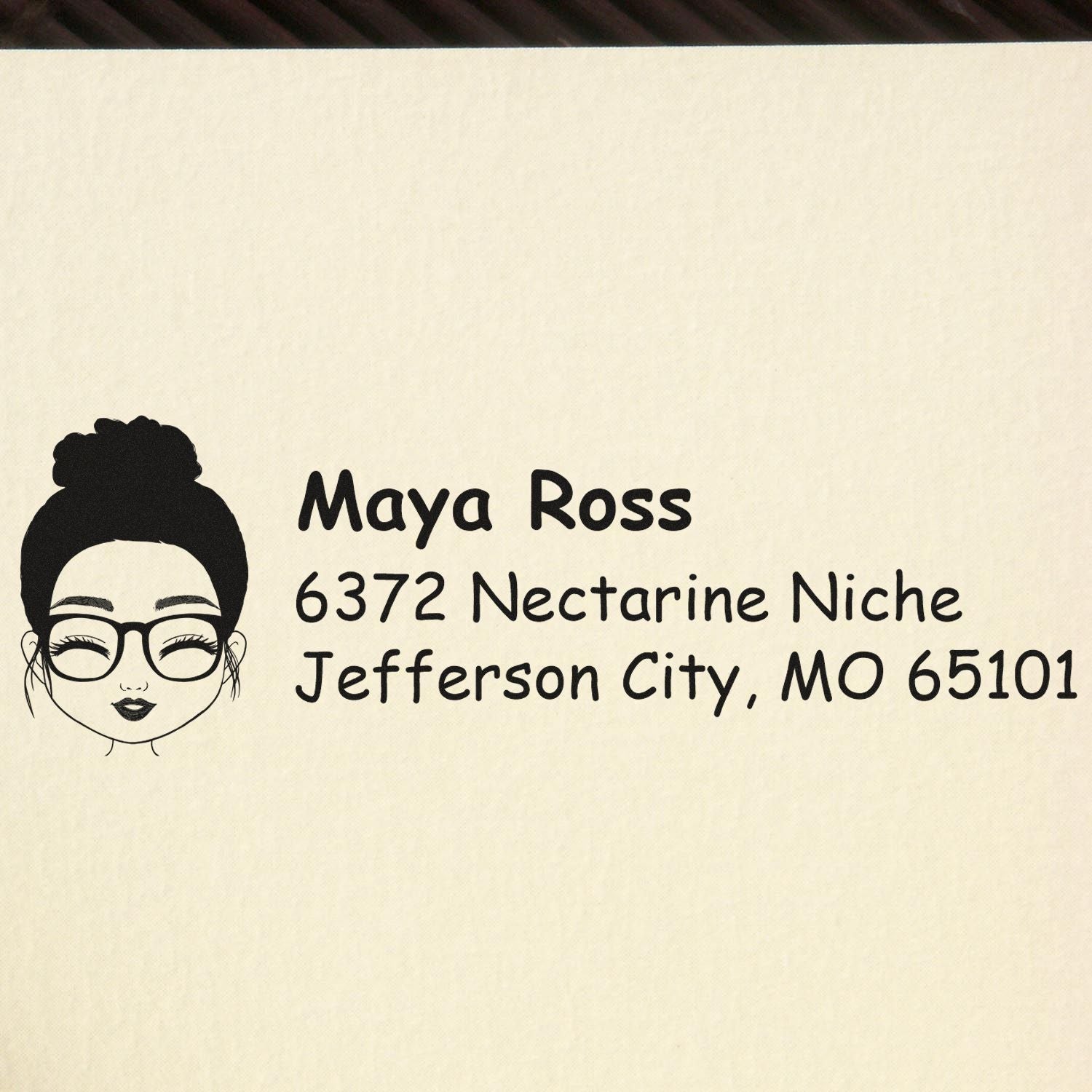 Personalized return address rubber stamp for Maya Ross in Jefferson City, MO, with illustrated face logo.