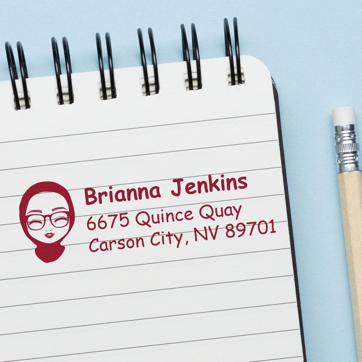 Custom return address stamp impression with name and address on a notebook page for mailing.