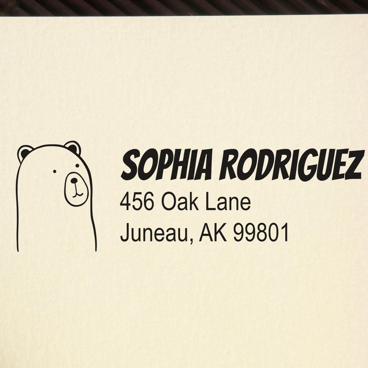 Custom rubber address stamp for Sophia Rodriguez, 456 Oak Lane, Juneau, AK 99801, with bear icon.