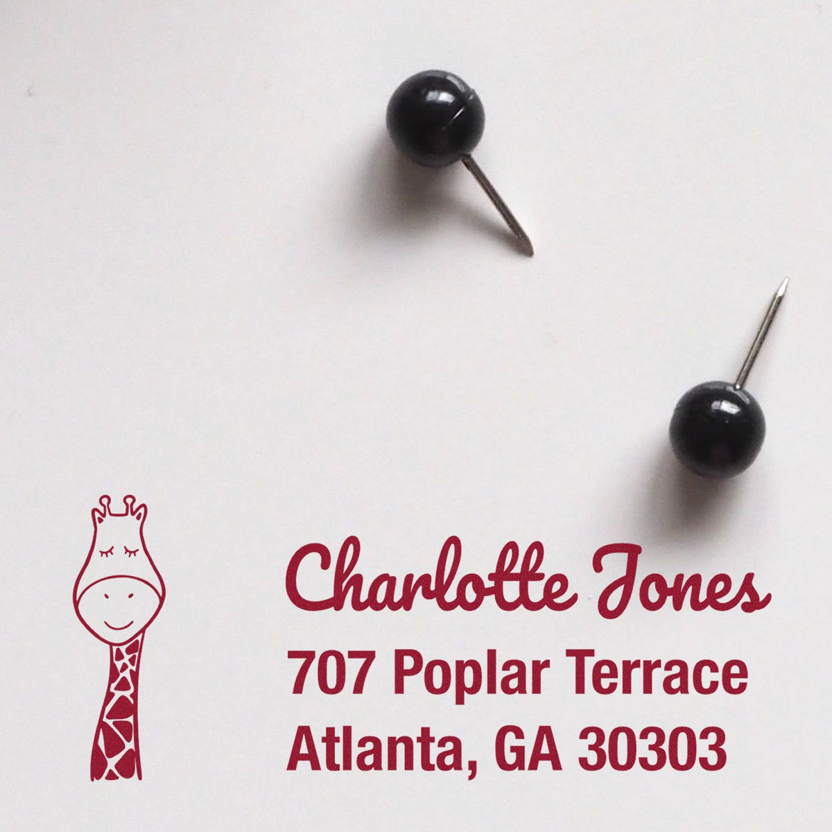 Custom rubber address stamp with giraffe logo, Charlotte Jones name, and Atlanta, GA return address.