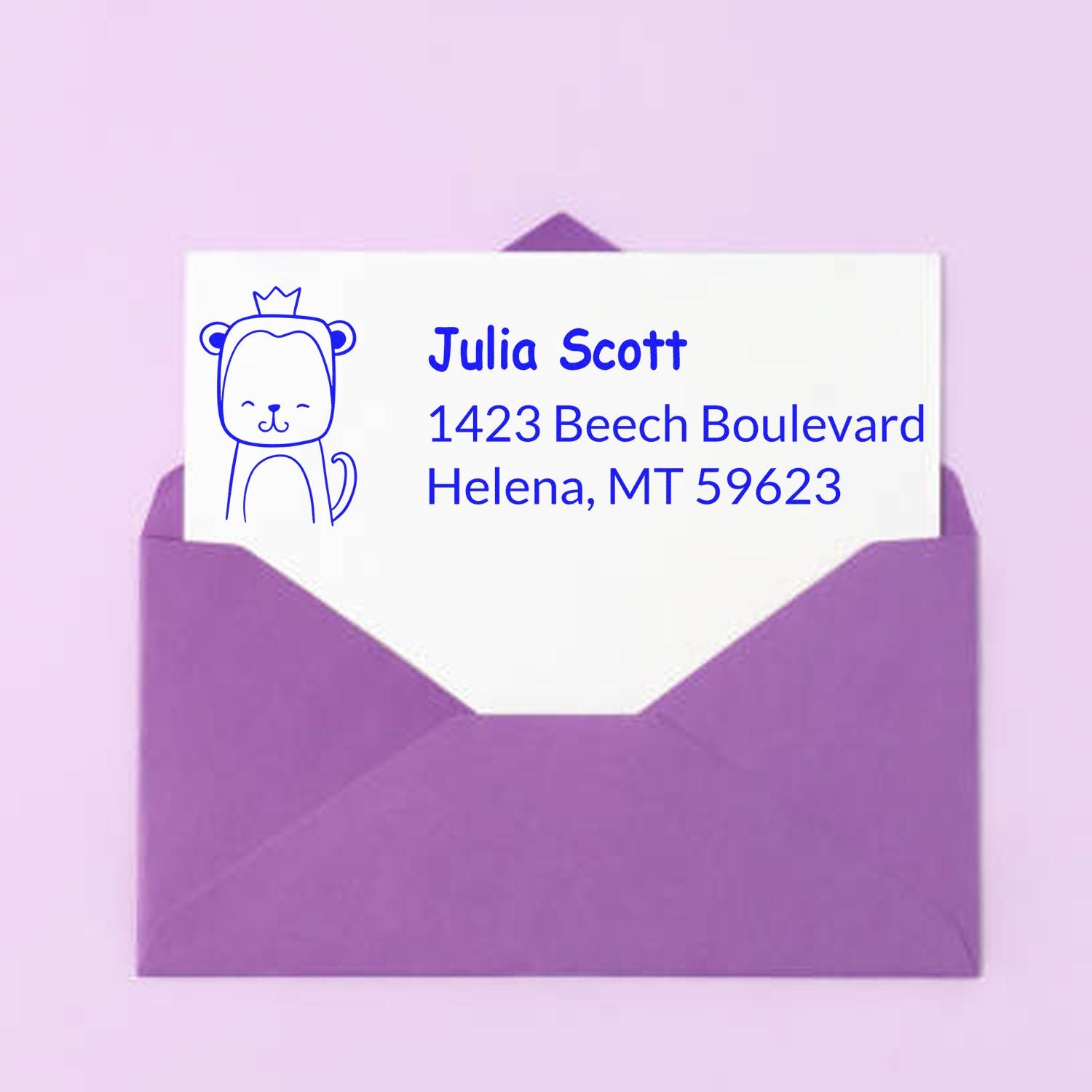 Personalized return address rubber stamp with bear design for Julia Scott, Helena, MT, shown on a purple envelope.