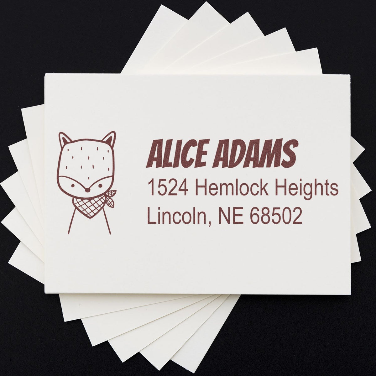 Custom return address rubber stamp with fox logo for Alice Adams, Lincoln, NE 68502, on stacked stationery cards.
