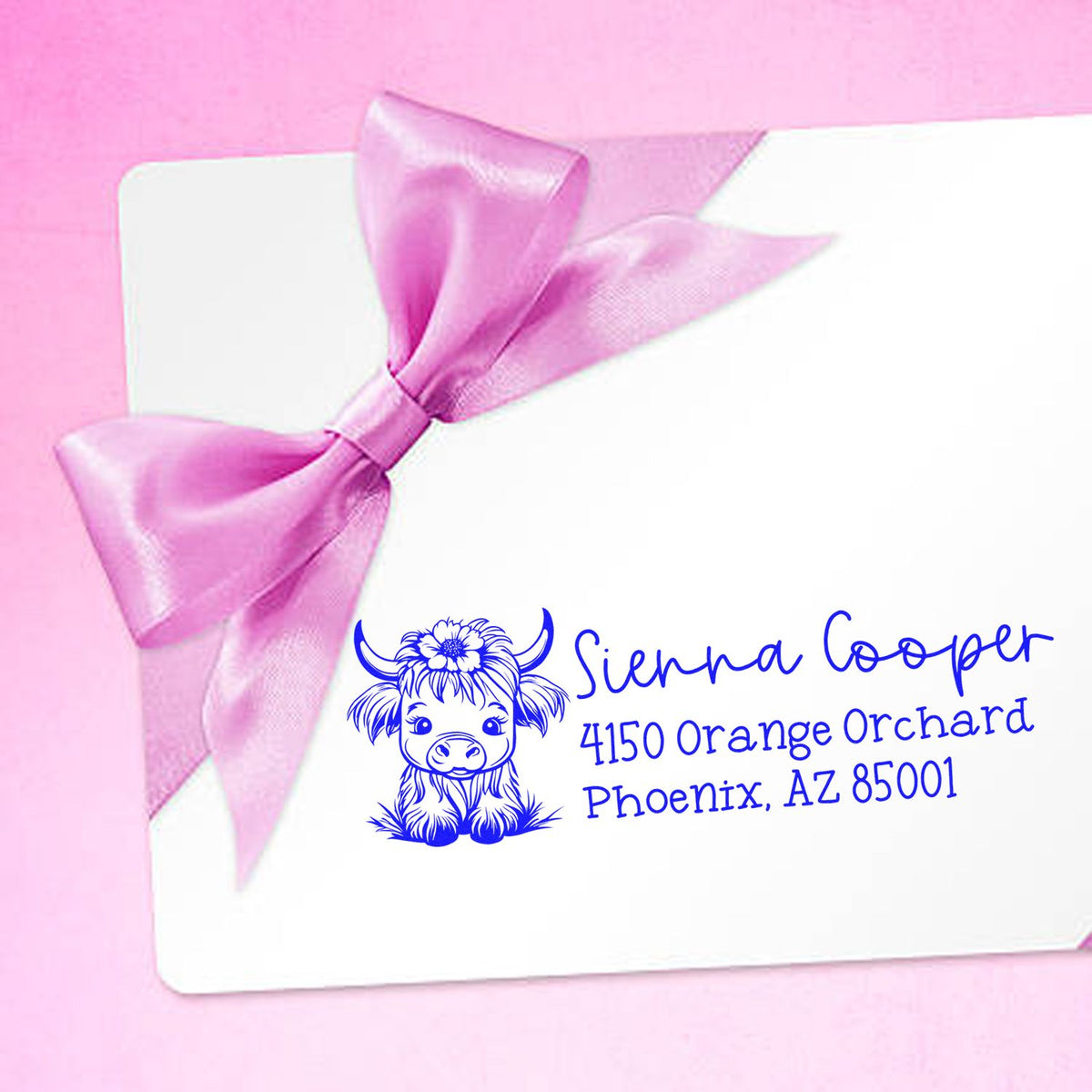 Personalized rubber return address stamp with cow logo for Sienna Cooper, Phoenix, AZ, on a pink gift envelope.
