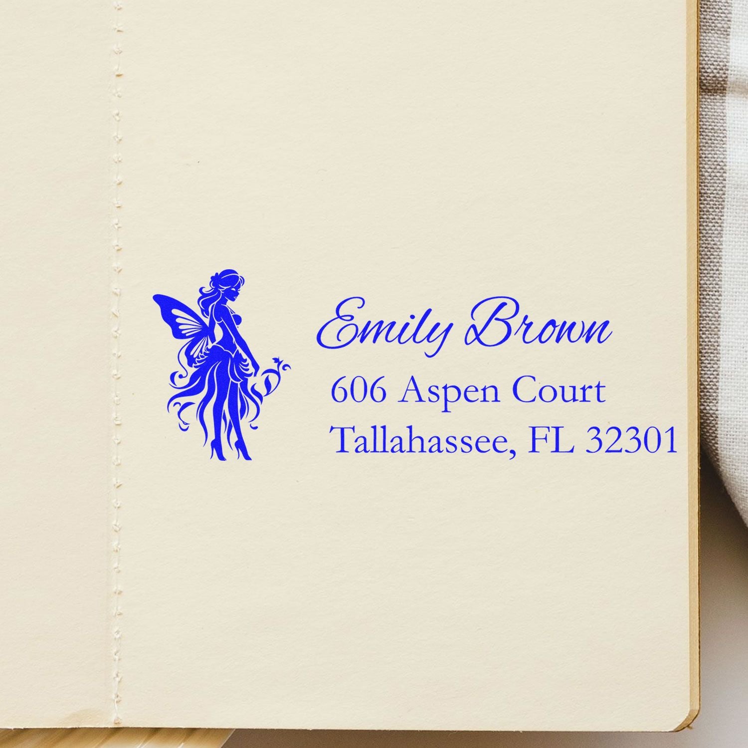 Custom fairy address rubber stamp featuring Emily Brown, 606 Aspen Court, Tallahassee, FL 32301 in blue ink.