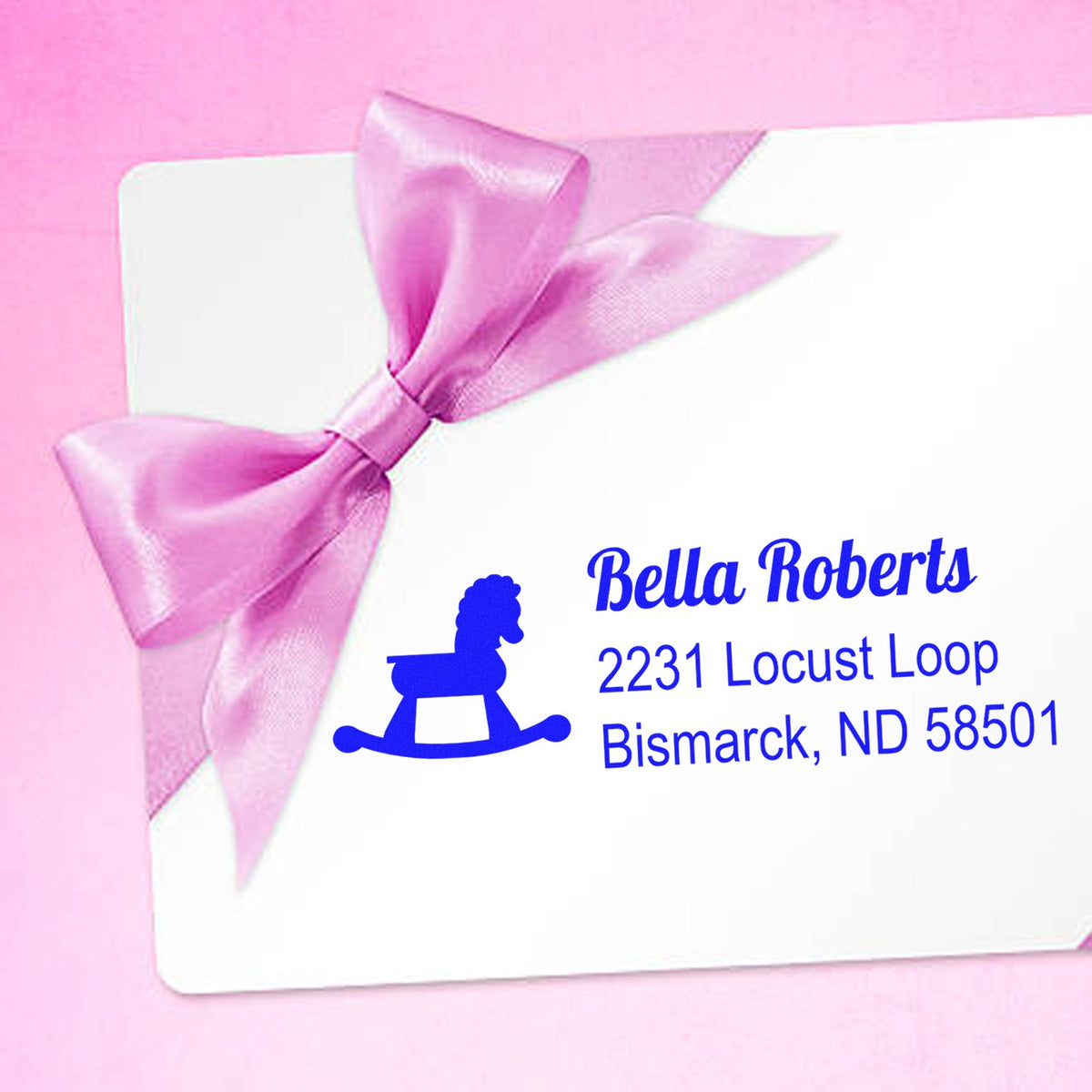 Custom return address rubber stamp with rocking horse icon for Bella Roberts, Bismarck, ND gift envelope.