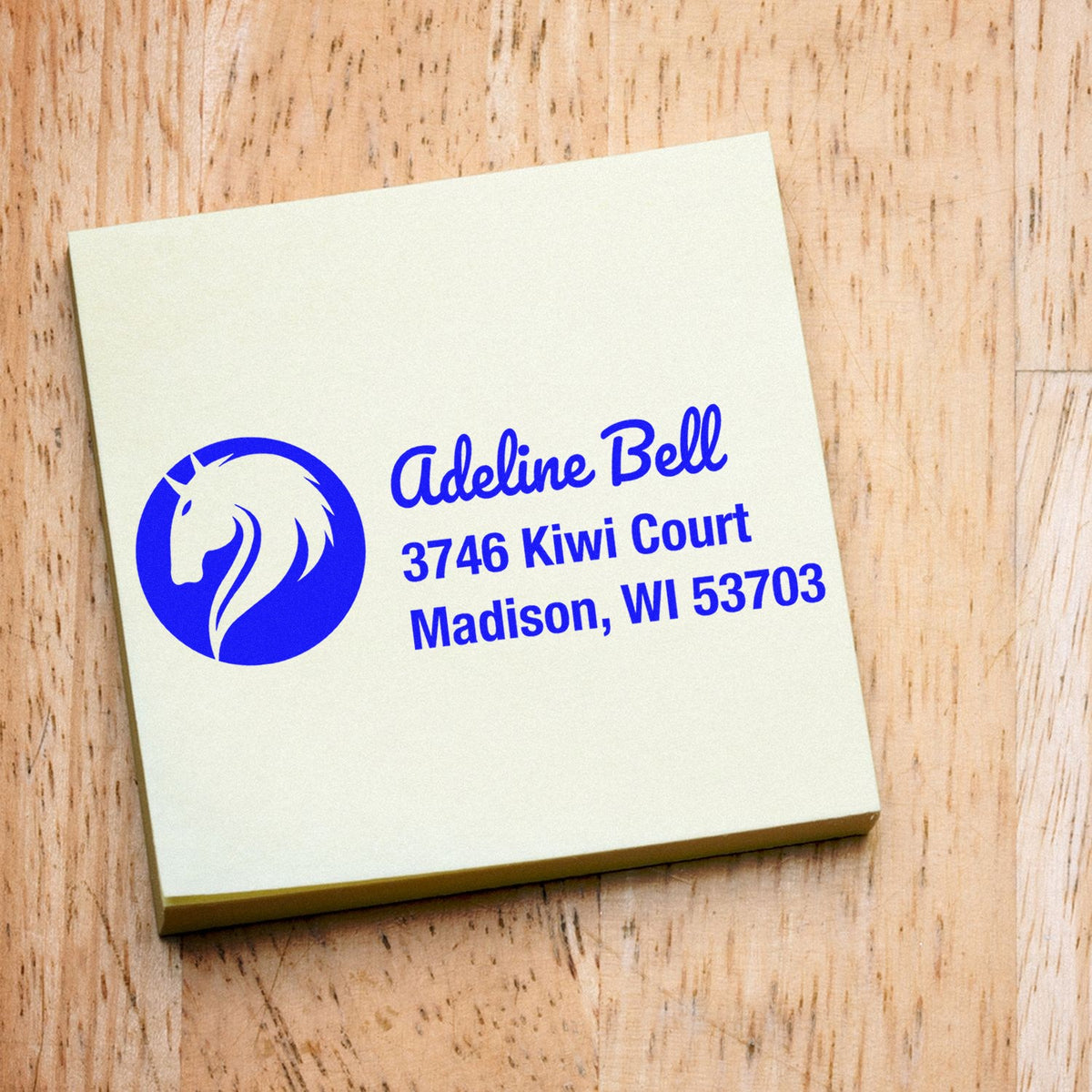 Custom return address rubber stamp with horse logo, Adeline Bell name, and Madison, WI address in blue ink.