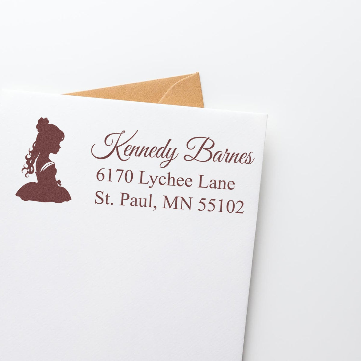 Personalized return address rubber stamp with girl silhouette for Kennedy Barnes on a white envelope.