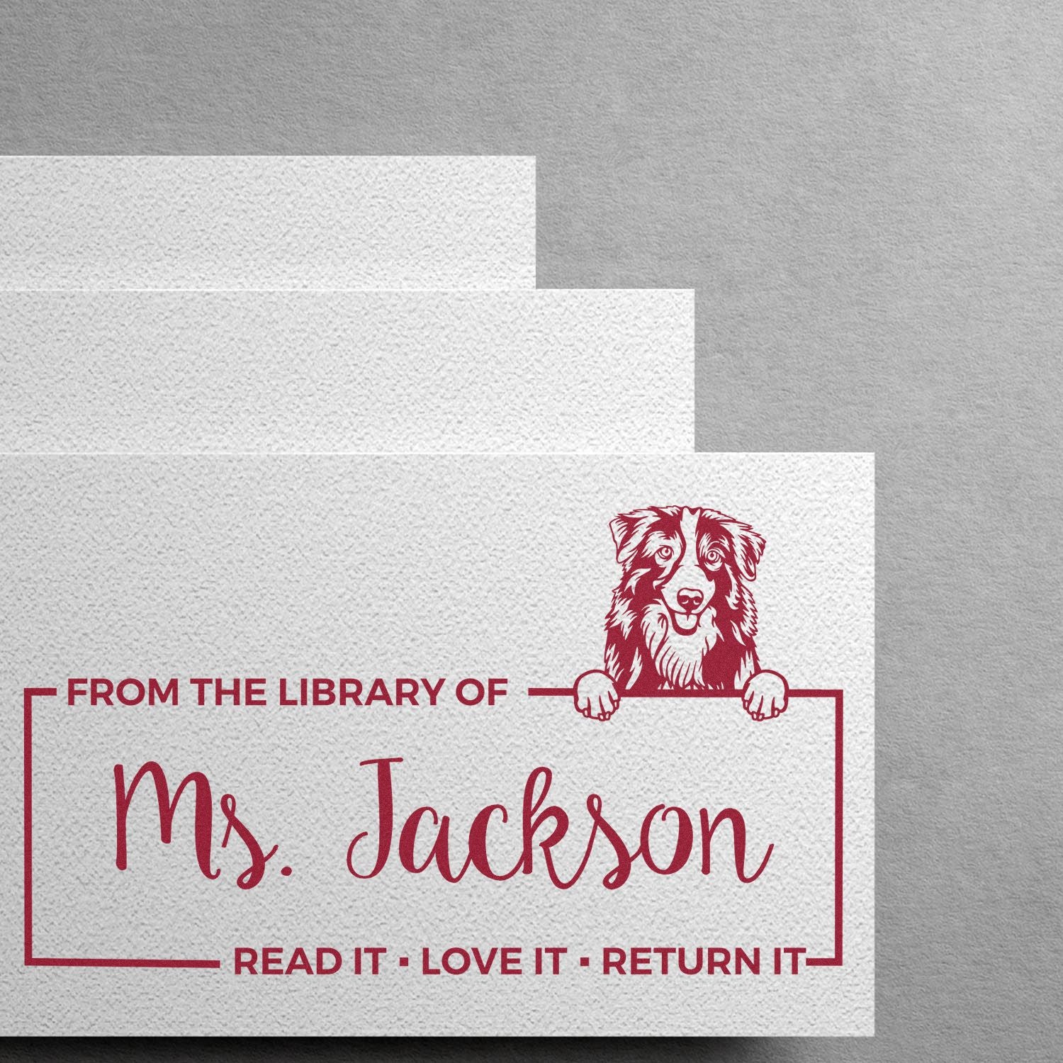 Personalized library rubber stamp for Ms. Jackson with dog mascot and Read It Love It Return It bookplate message.