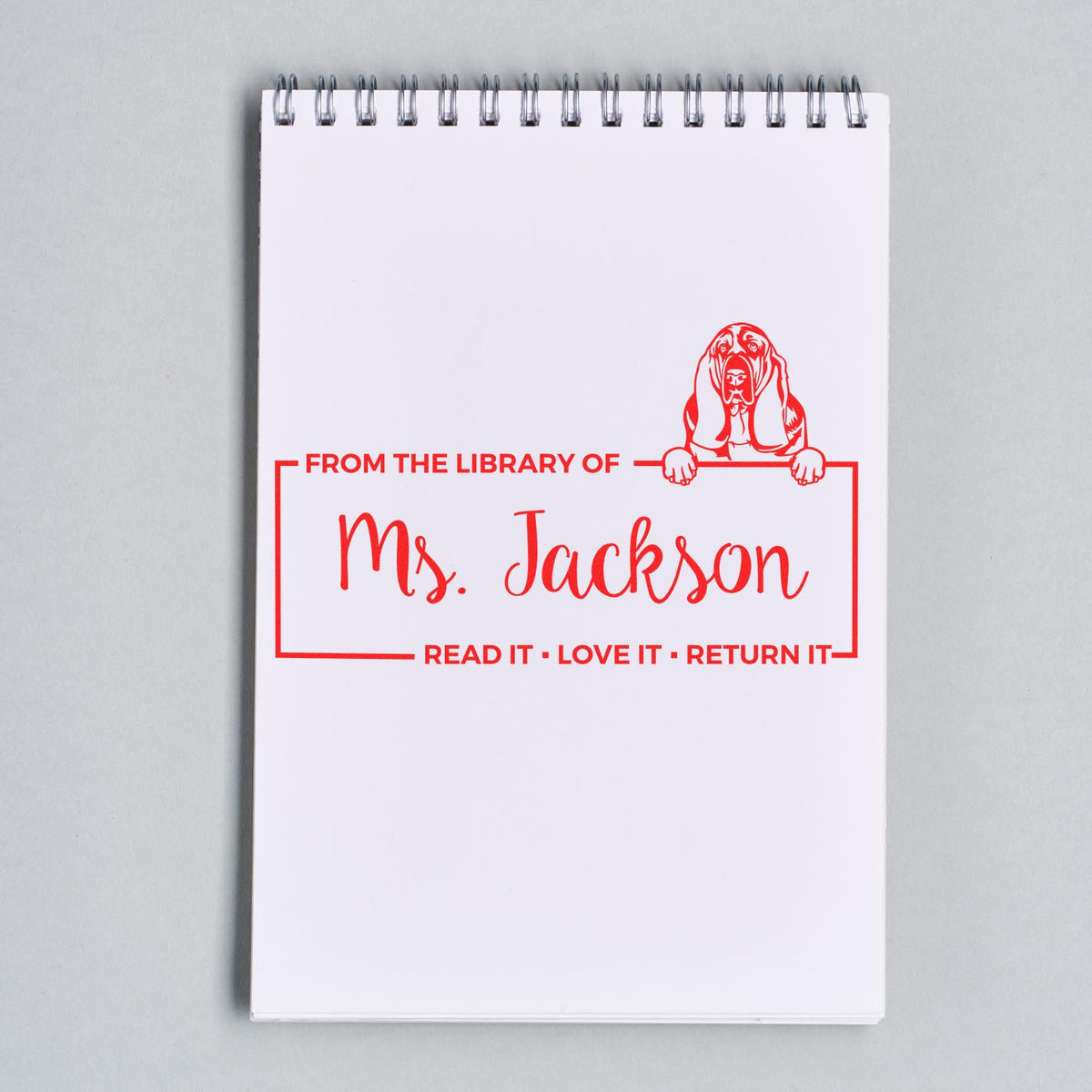 Custom personalized library rubber stamp with red dog design and From the Library of Ms. Jackson for book returns.