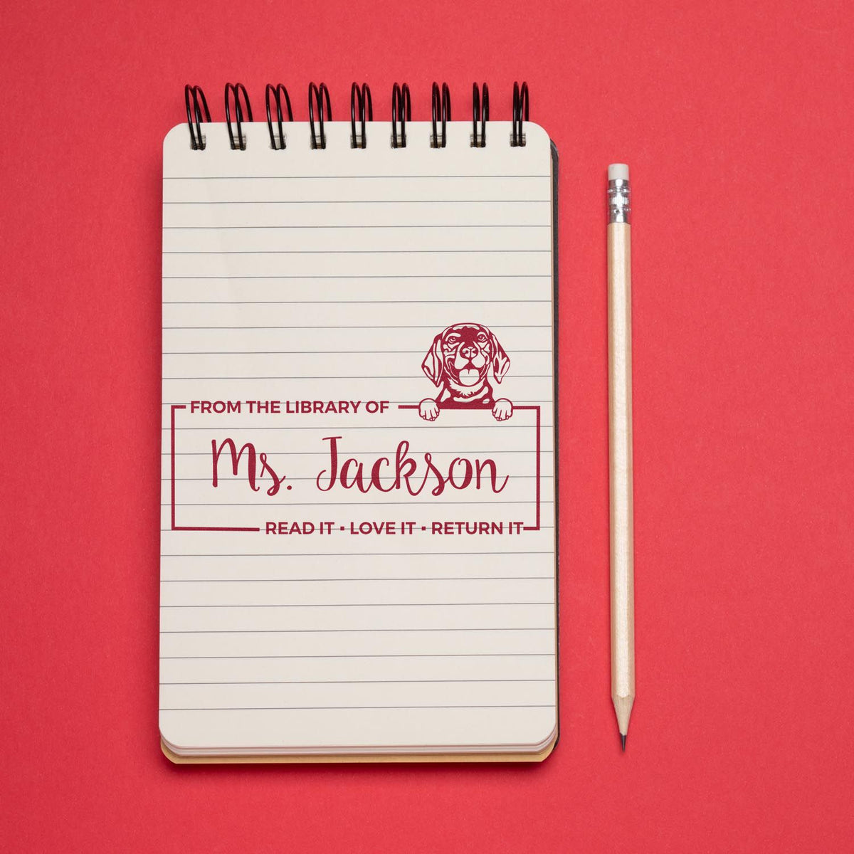 Personalized library book stamp for Mrs. Jackson with dog design and Read it, love it, return it message.