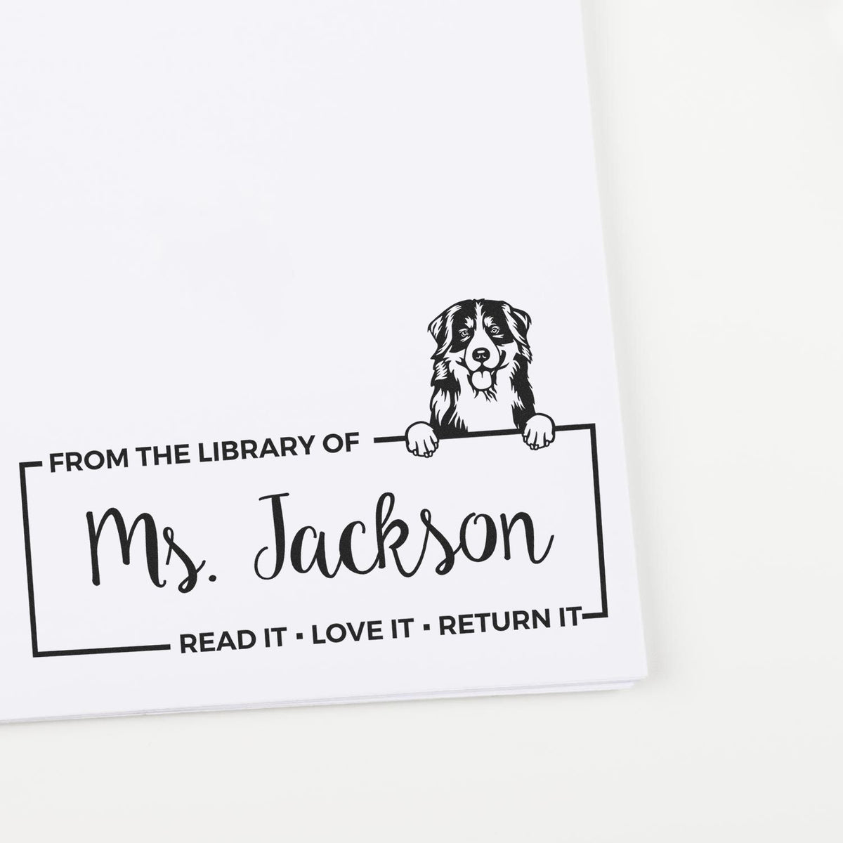 Custom personalized book stamp with dog design and From the Library of Ms. Jackson return-it reminder.