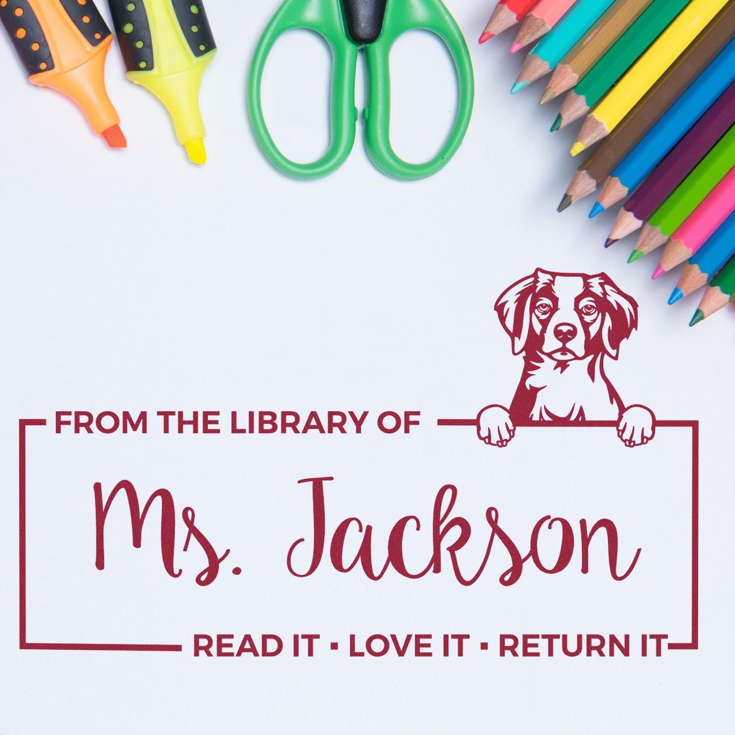 Personalized rubber library book stamp with dog design and From the Library of Ms. Jackson return-it message.
