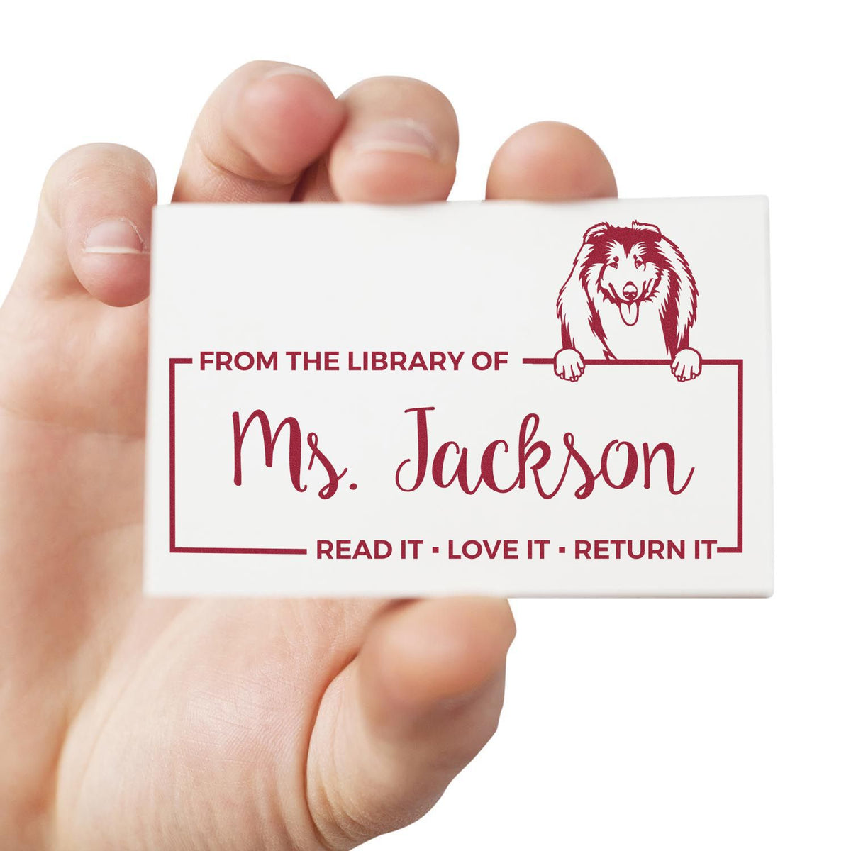 Hand holding custom rubber library stamp for Ms. Jackson with dog logo and Read it, love it, return it text.