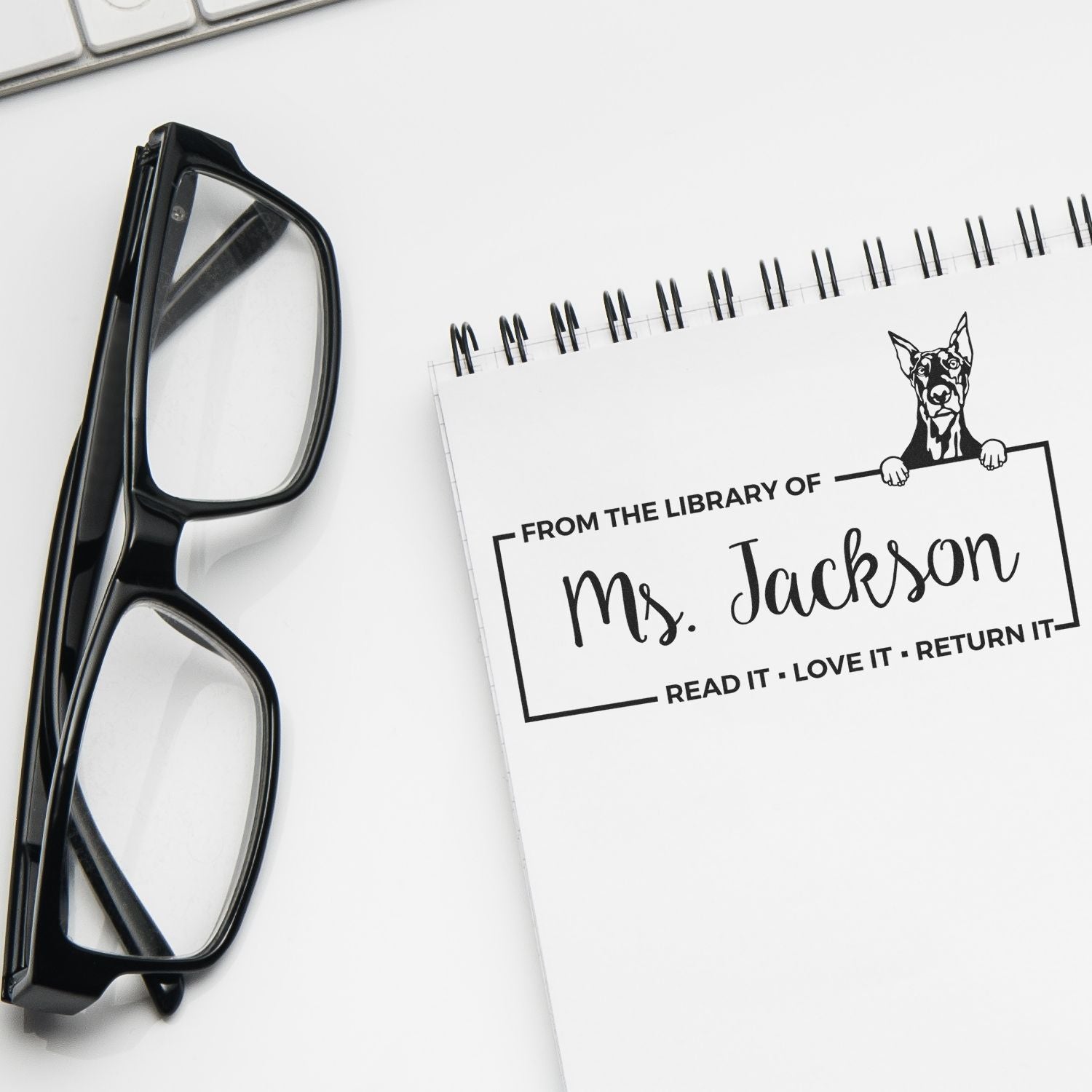 Personalized rubber library stamp with dog design, labeled From the Library of Ms. Jackson for books and returns.