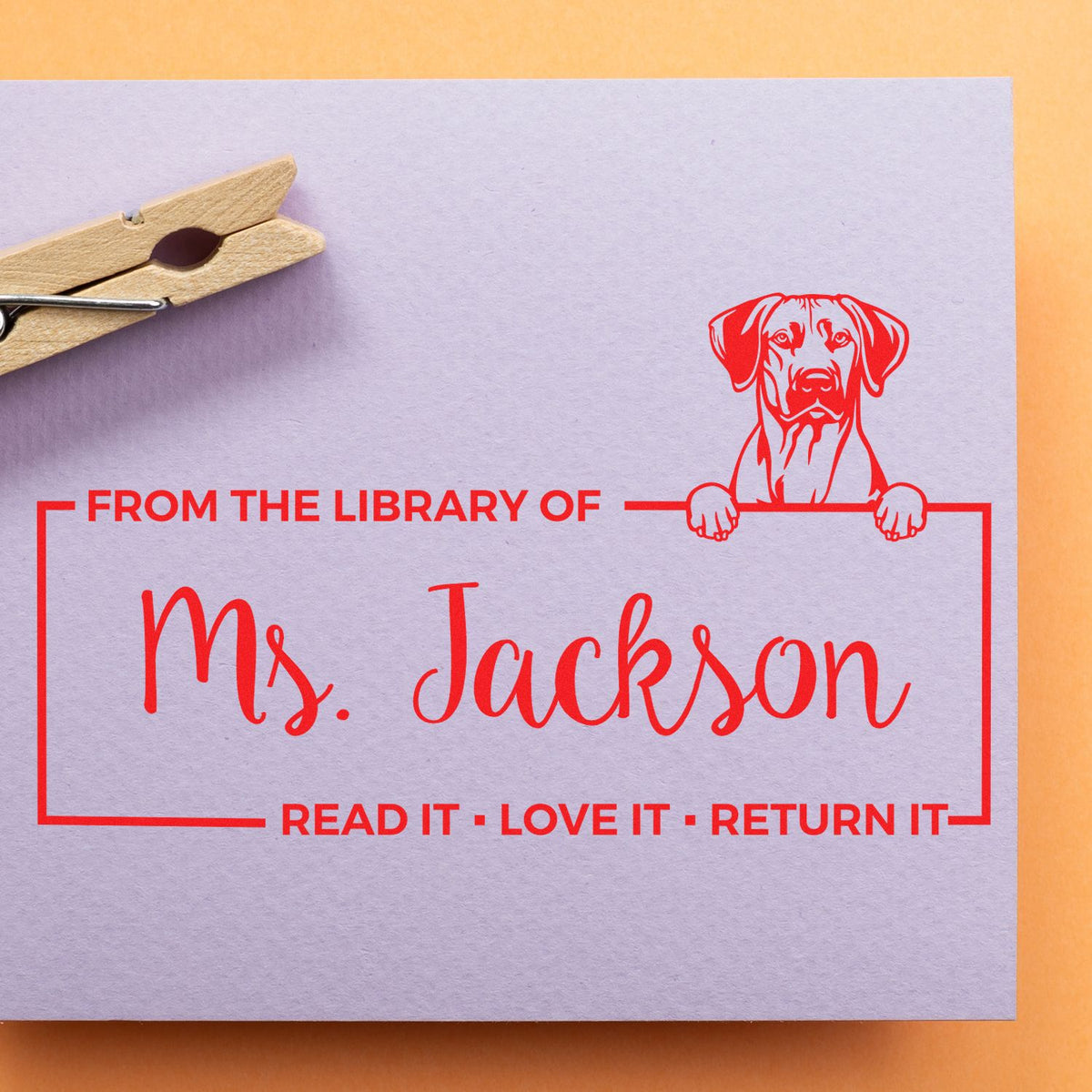 Custom rubber library stamp with dog design and From the Library of Ms. Jackson book return reminder on paper