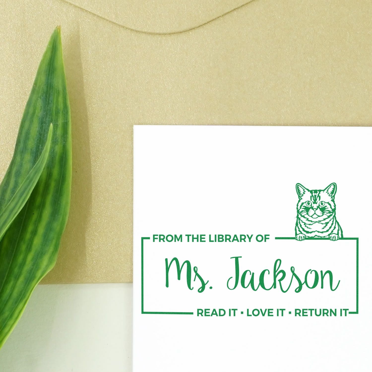 Custom library book rubber stamp with cat design and Ms. Jackson name, for marking books with Read it, love it, return it.