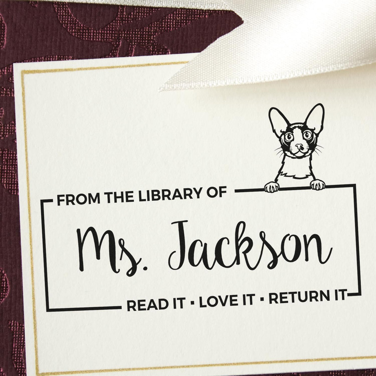 Personalized library rubber stamp for Ms. Jackson with dog illustration and From the Library of book return message.
