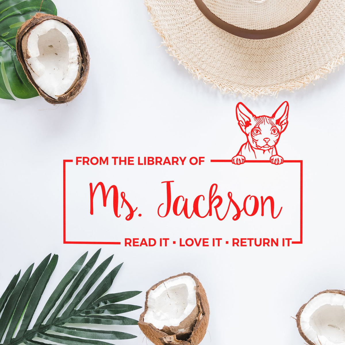 Custom cat library rubber stamp reading From the Library of Ms. JacksonRead it, love it, return it on a flat lay background.