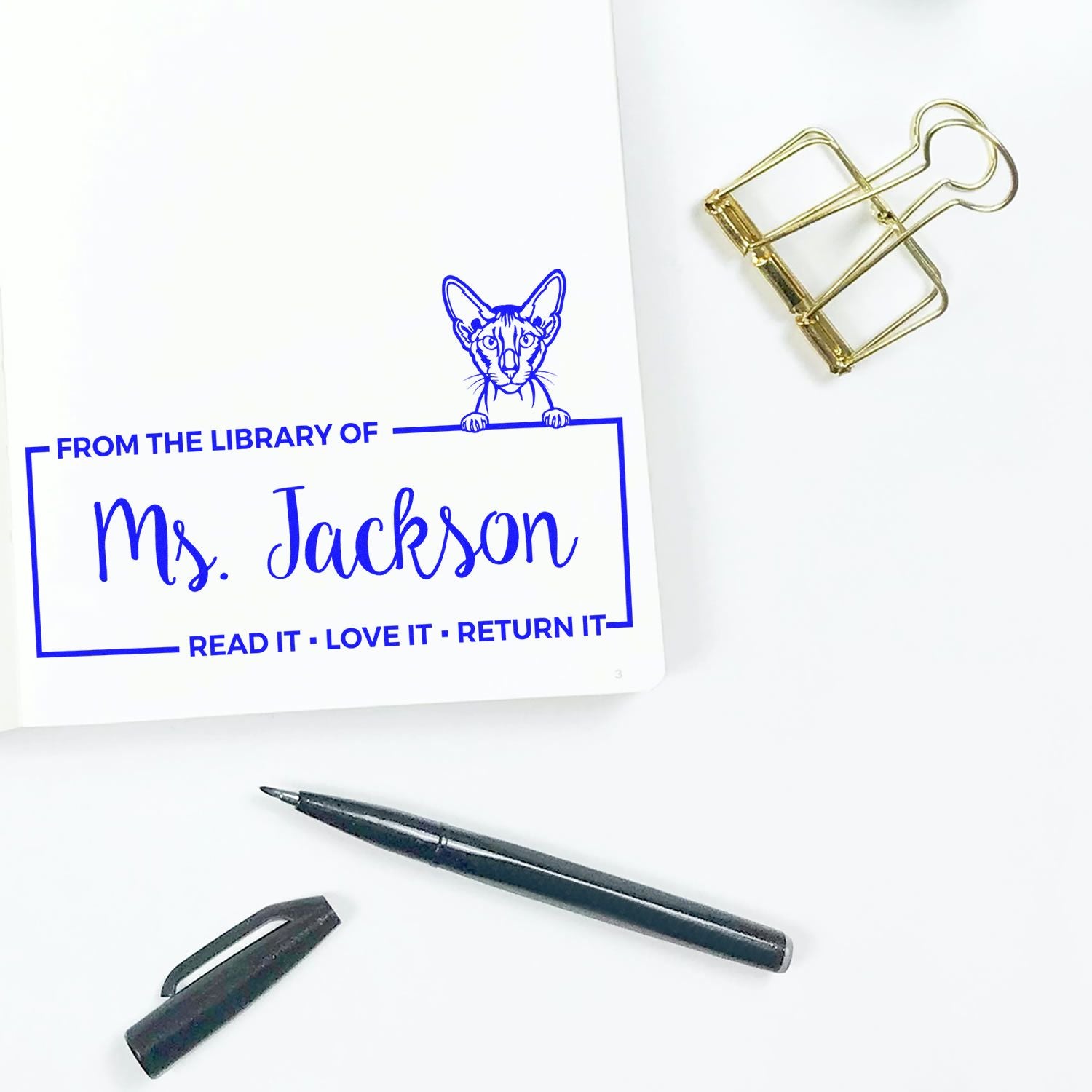 Custom rubber stamp impression reading From the Library of Ms. Jackson with cat design for personalized book return labels.