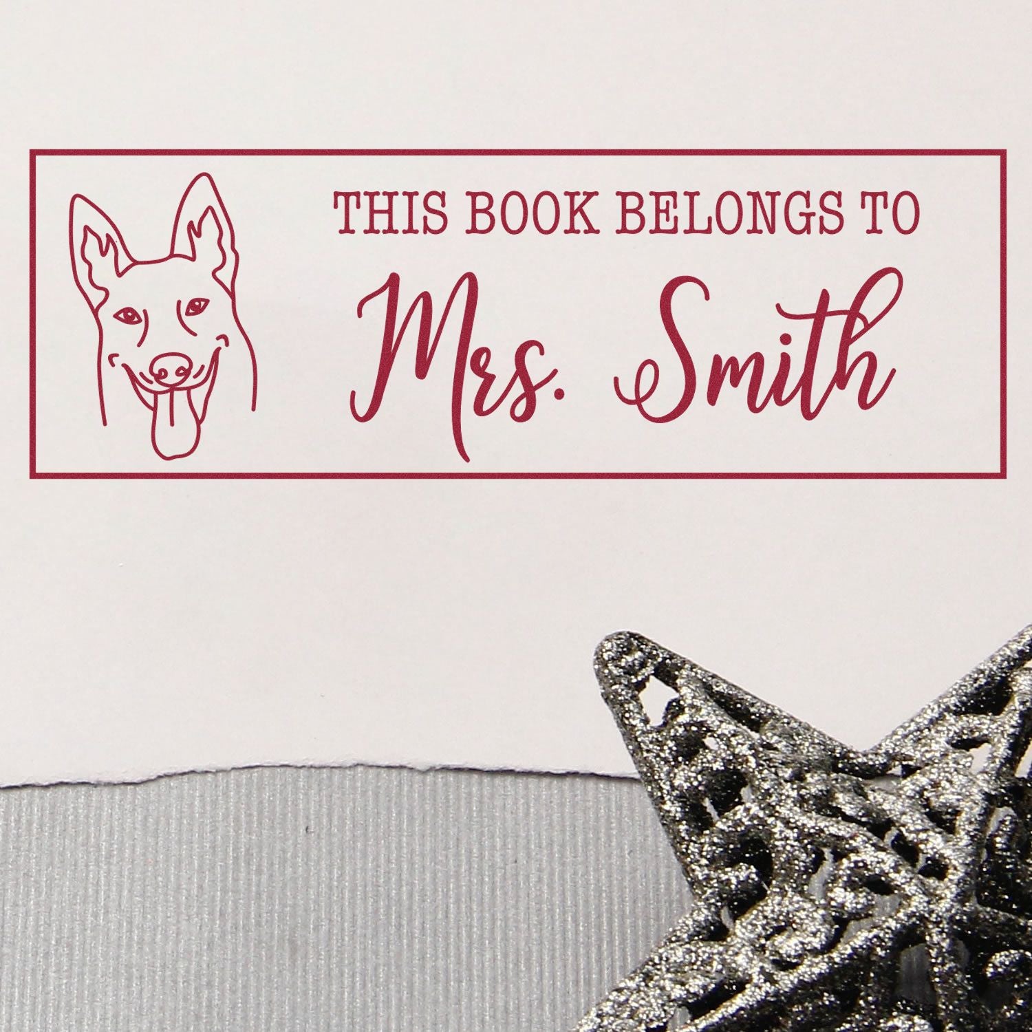 Personalized rubber stamp with dog illustration and This Book Belongs to Mrs. Smith text for custom library books.