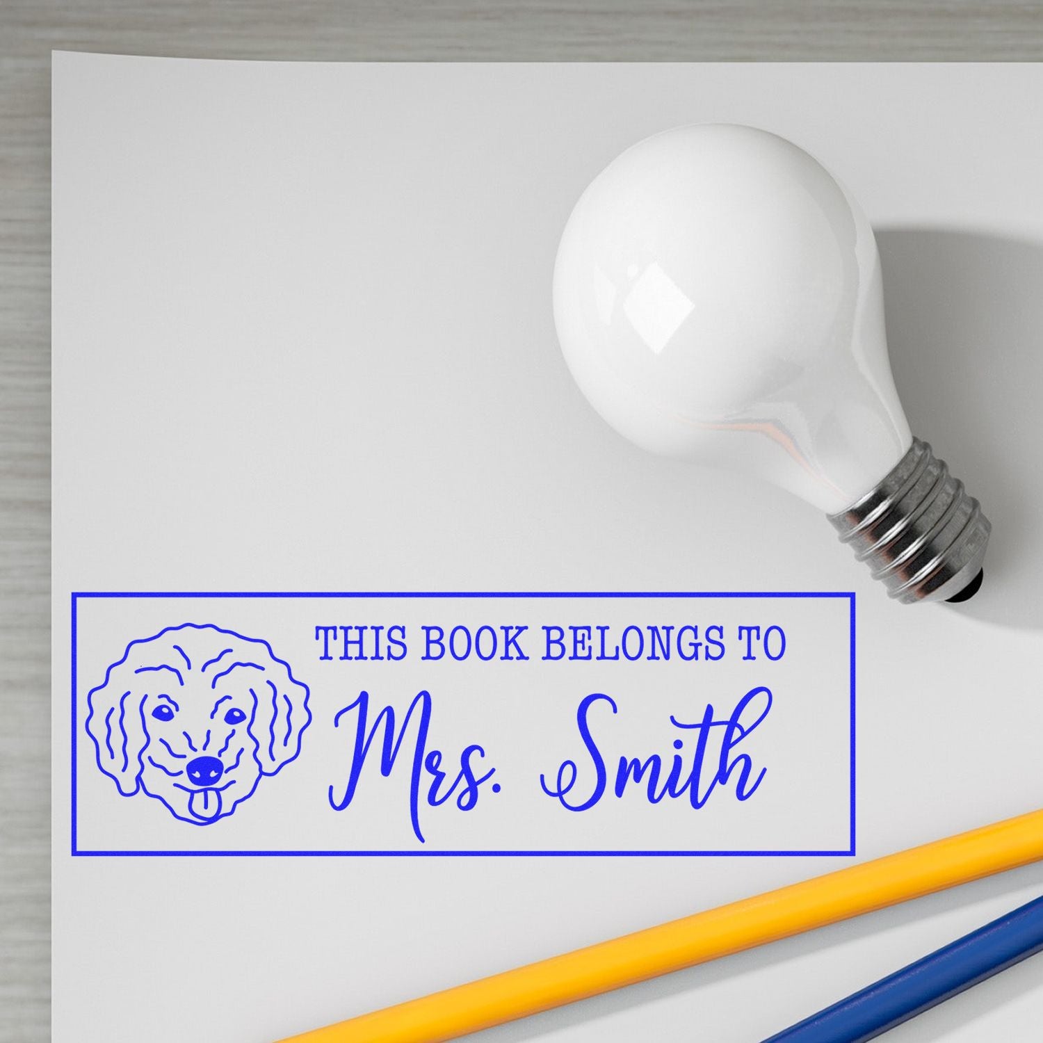 Personalized rubber book stamp with dog design and This Book Belongs to Mrs. Smith for custom library labels