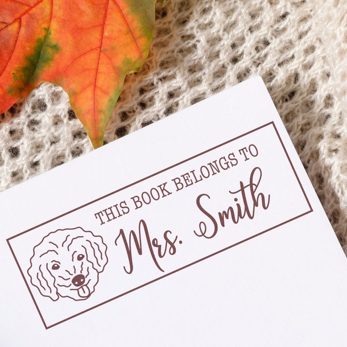 Custom rubber stamp bookplate reading This Book Belongs to Mrs. Smith with dog illustration for personalized library books.