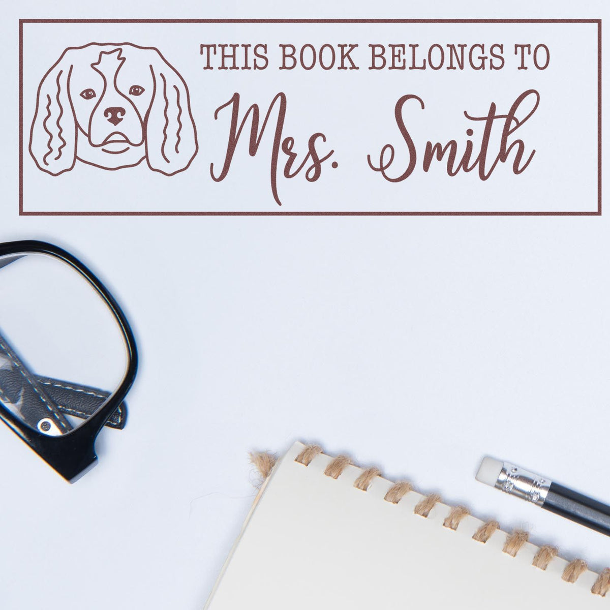 Personalized rubber book stamp with dog illustration and This Book Belongs to Mrs. Smith for custom library books.