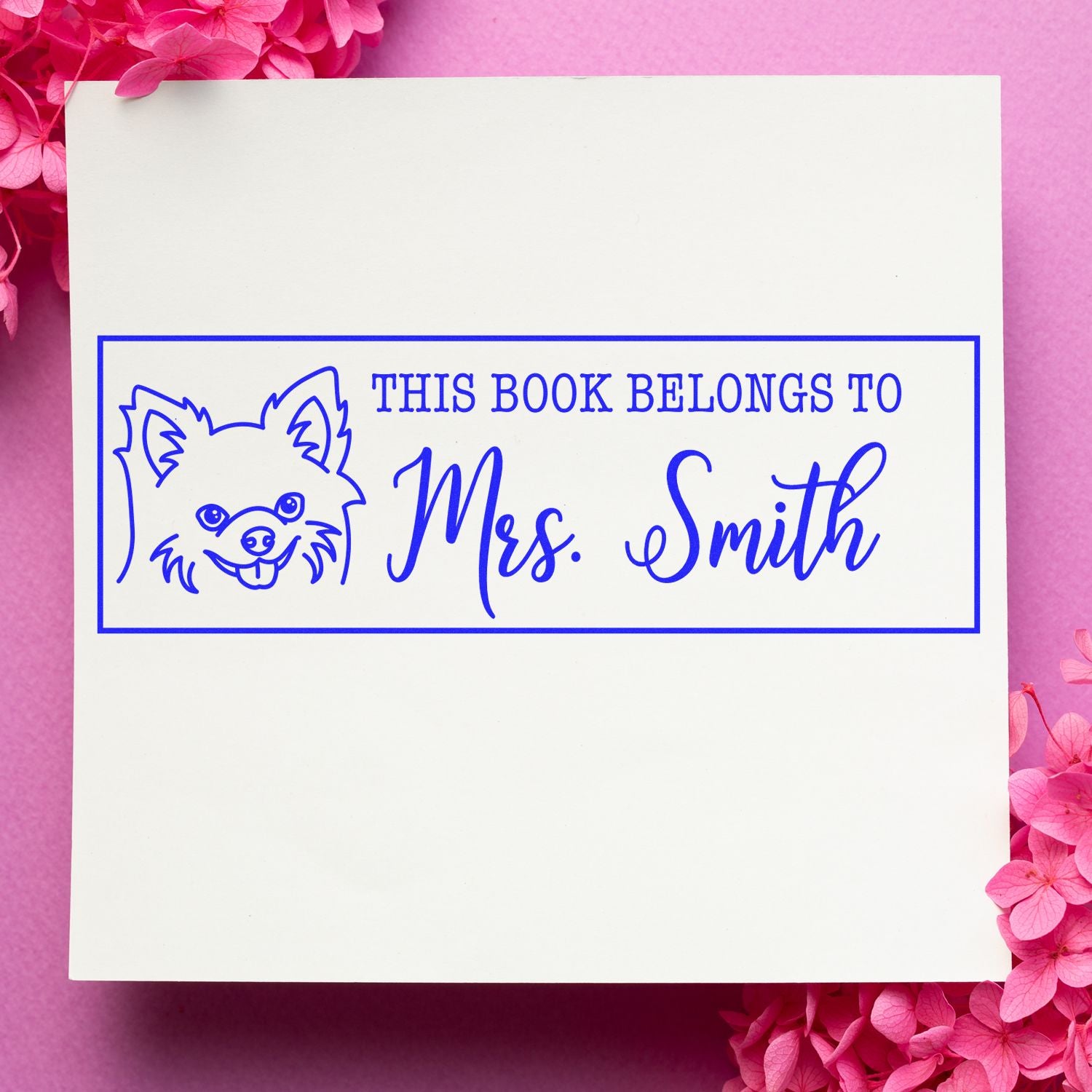 Custom rubber stamp for books with dog illustration and This Book Belongs To Mrs. Smith text.