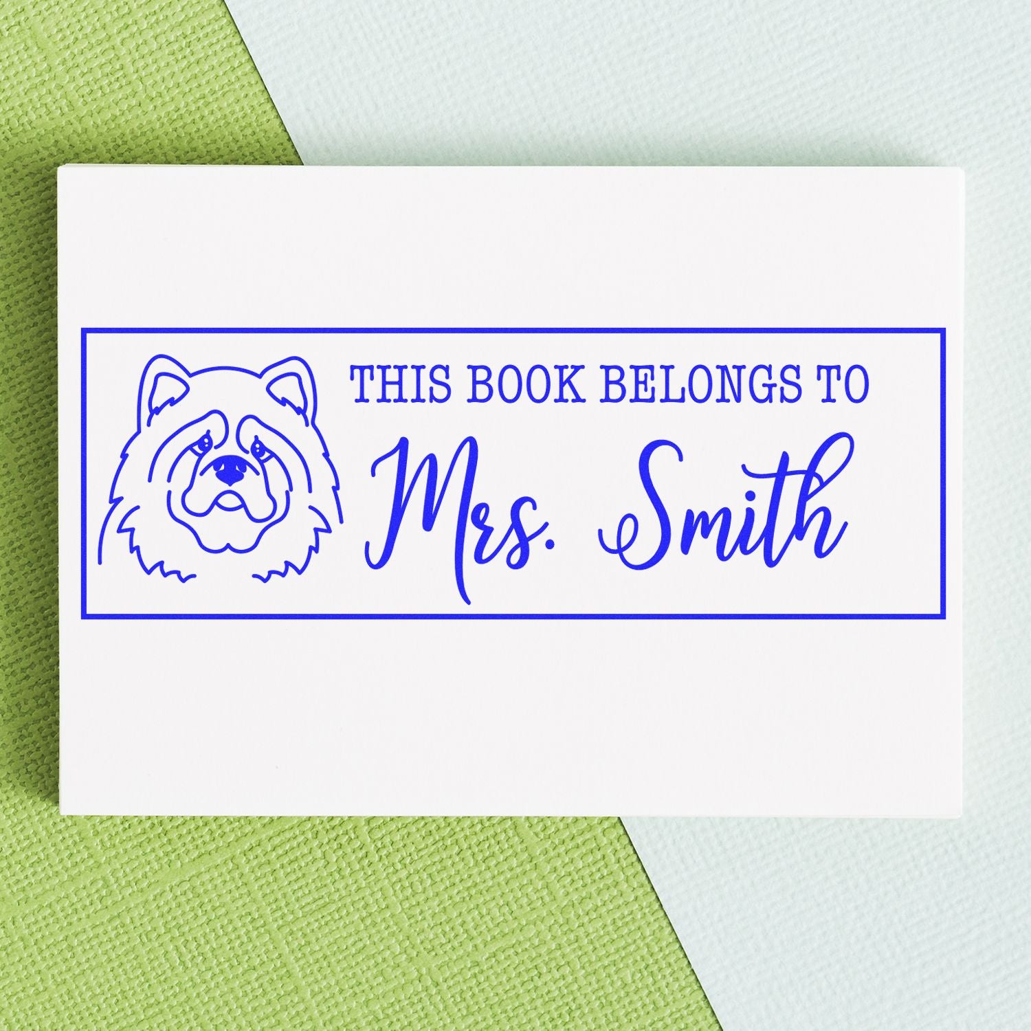 Custom rubber book stamp with dog illustration and This Book Belongs to Mrs. Smith for personalized library books.