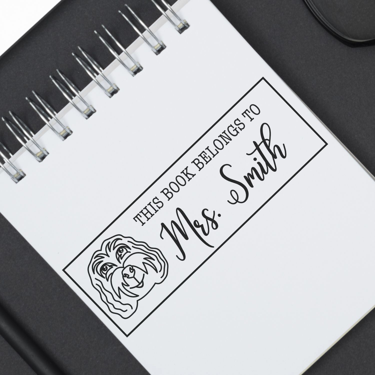 Custom rubber stamp for books reading This Book Belongs to Mrs. Smith with dog illustration.