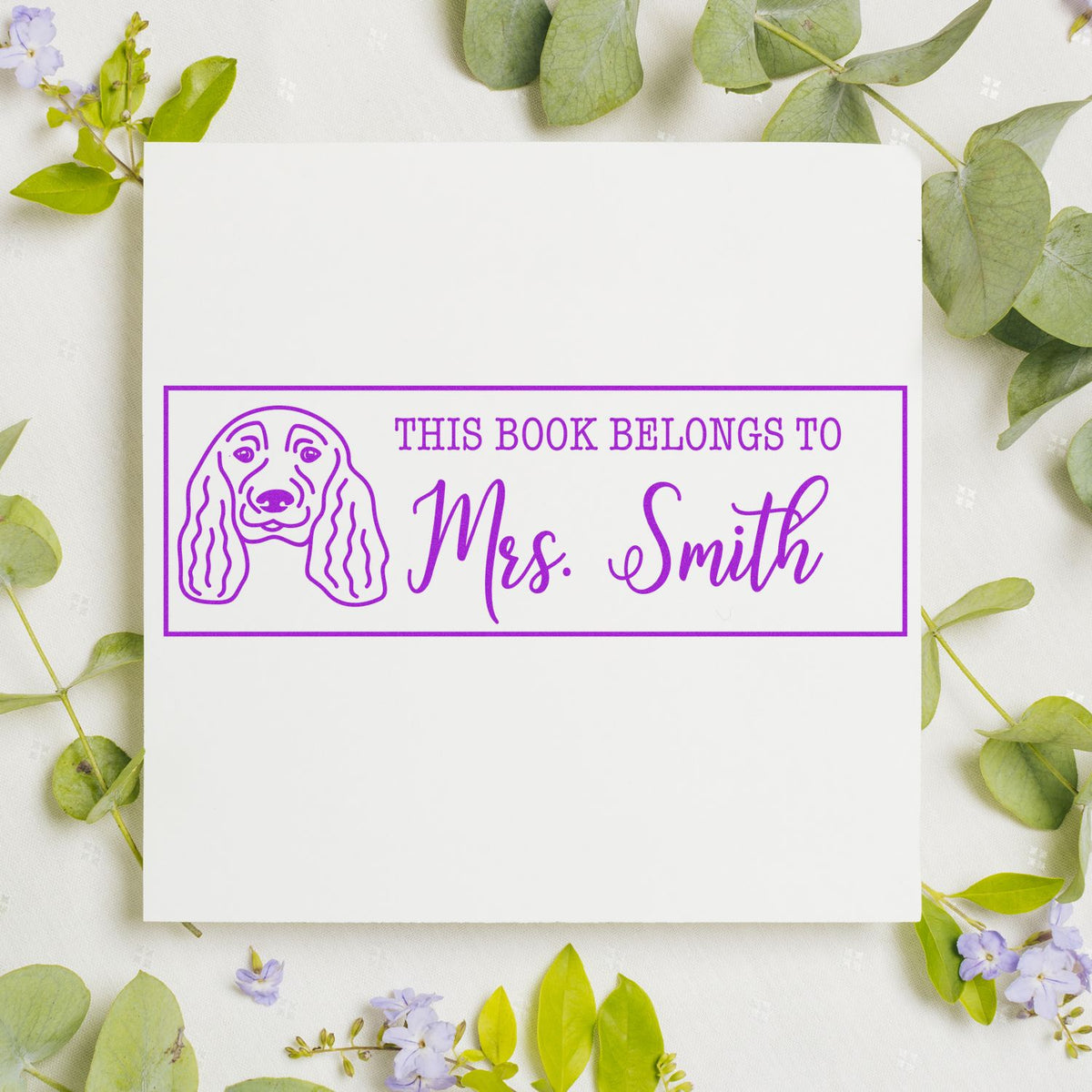 Custom purple rubber stamp with dog portrait and This Book Belongs to Mrs. Smith personalized book label.